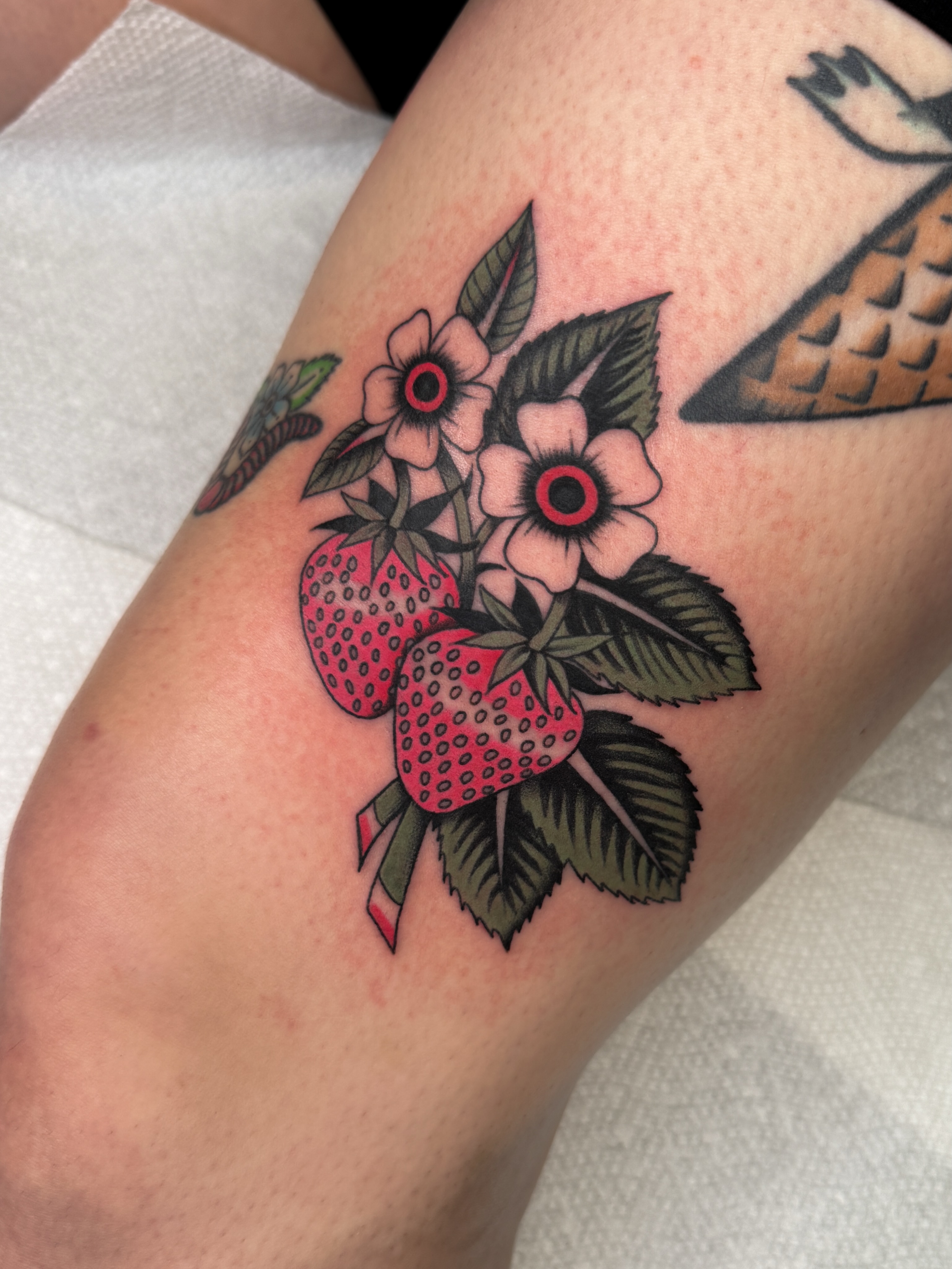 Strawberries and flowers American traditional tattoo on the forearm by Allie Barringer