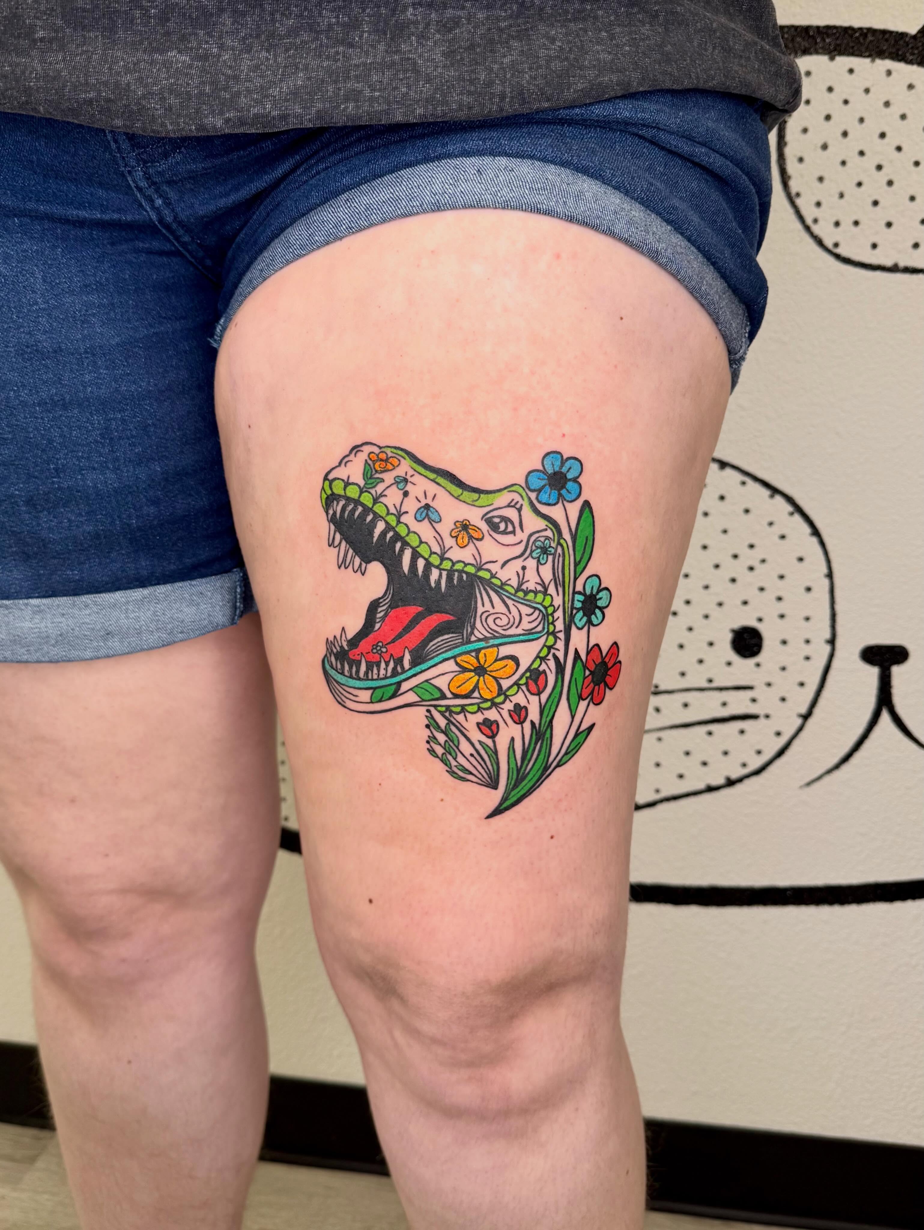 Dinosaur skull with flowers new school tattoo on the thigh by Peggy