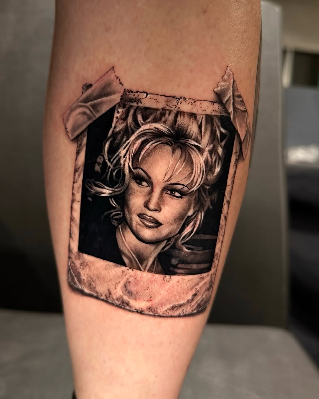 Pamela Anderson portrait in polaroid frame realism tattoo on the forearm by Tommy Nguyen, Eastpointe, Michigan