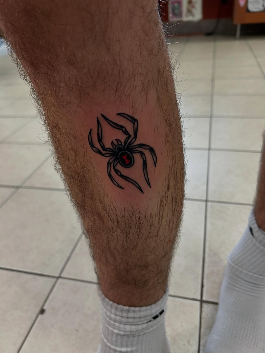 Black widow spider blackwork tattoo on the calf by Elizabeth Niederkorn