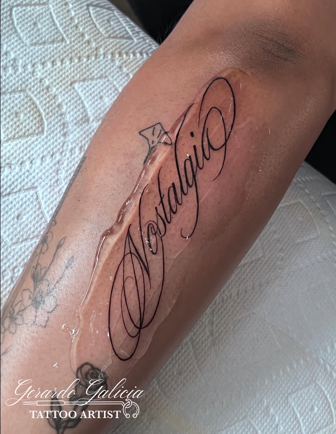 Nostalgia script lettering lettering tattoo on the forearm by Gerardo Galicia, New York, New York
