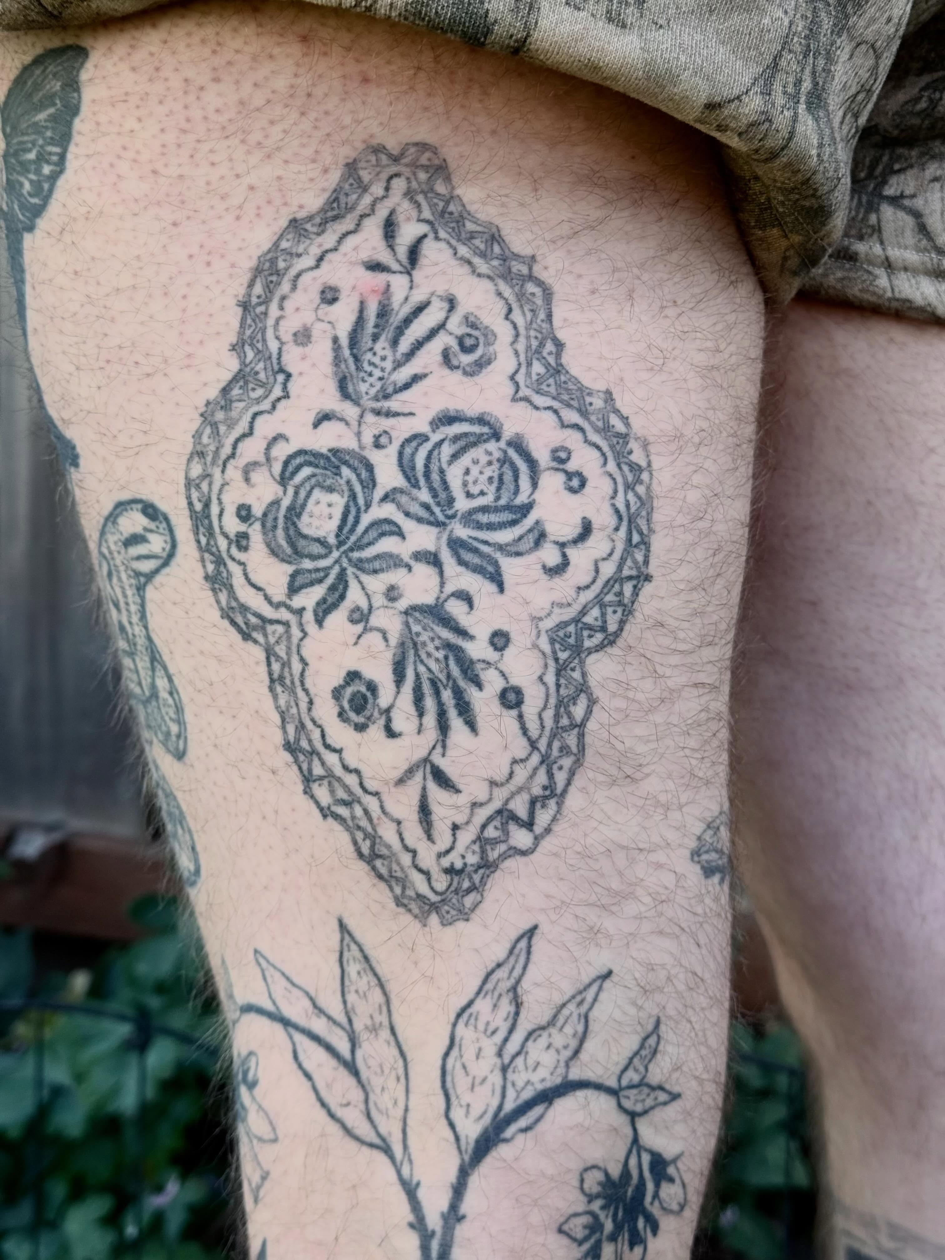 Floral medallion black and grey tattoo on the thigh by Emily Rose Lumsdaine