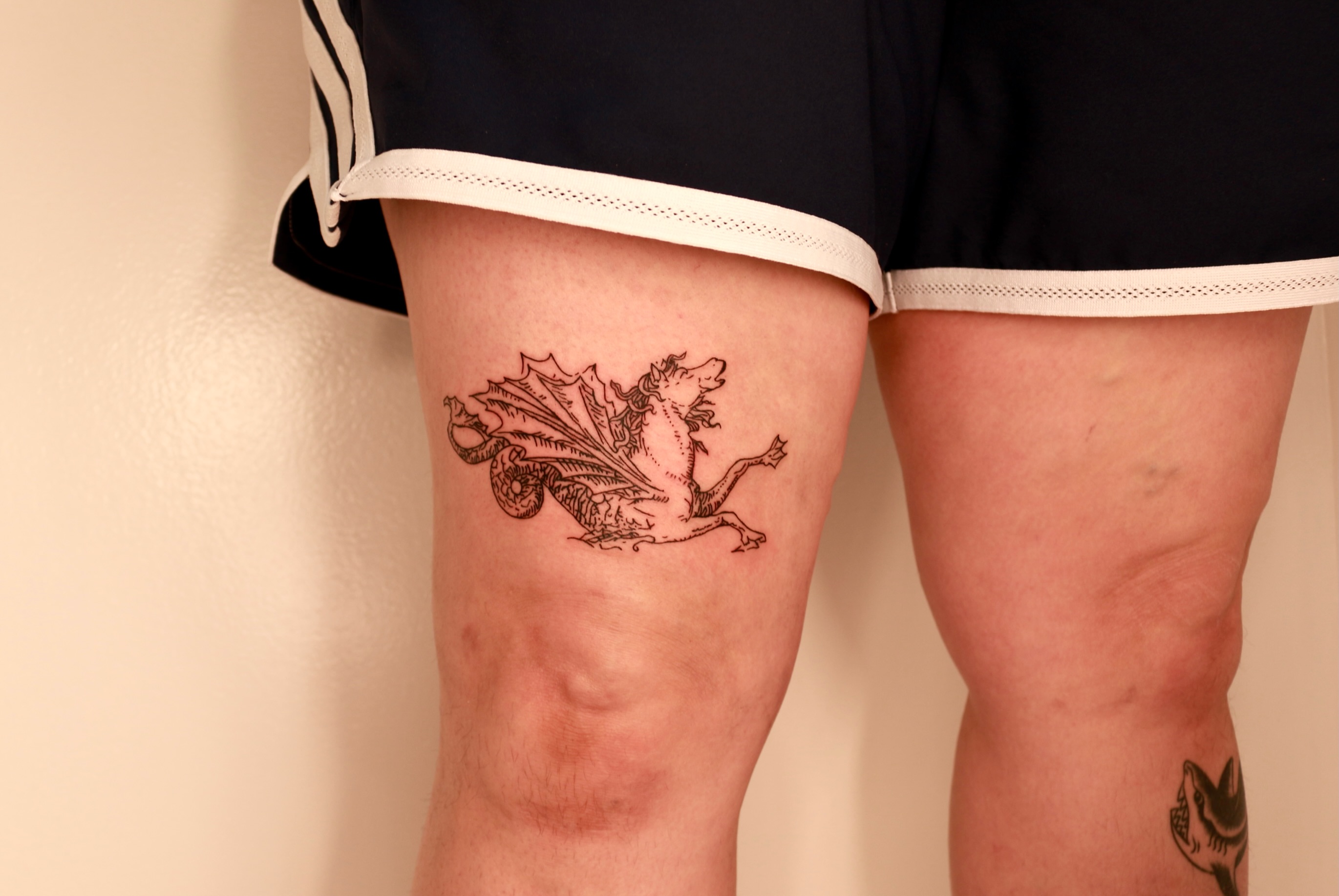 Winged dragon black and grey tattoo on the thigh by Mike