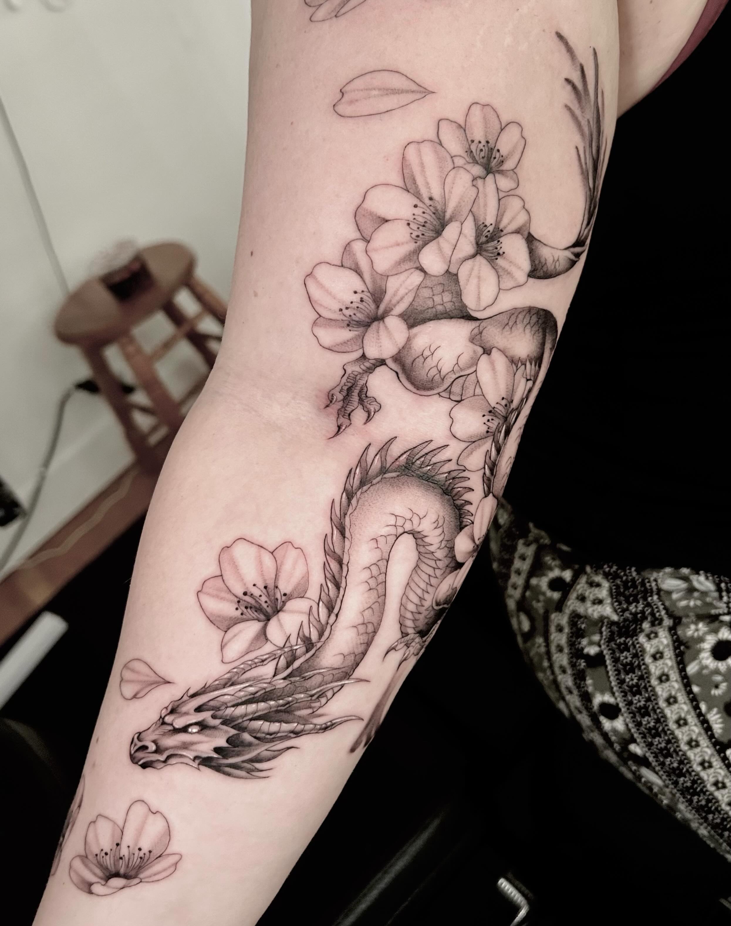 Dragon and flowers realism tattoo on the forearm by Jonny Tattoo PHX AZ