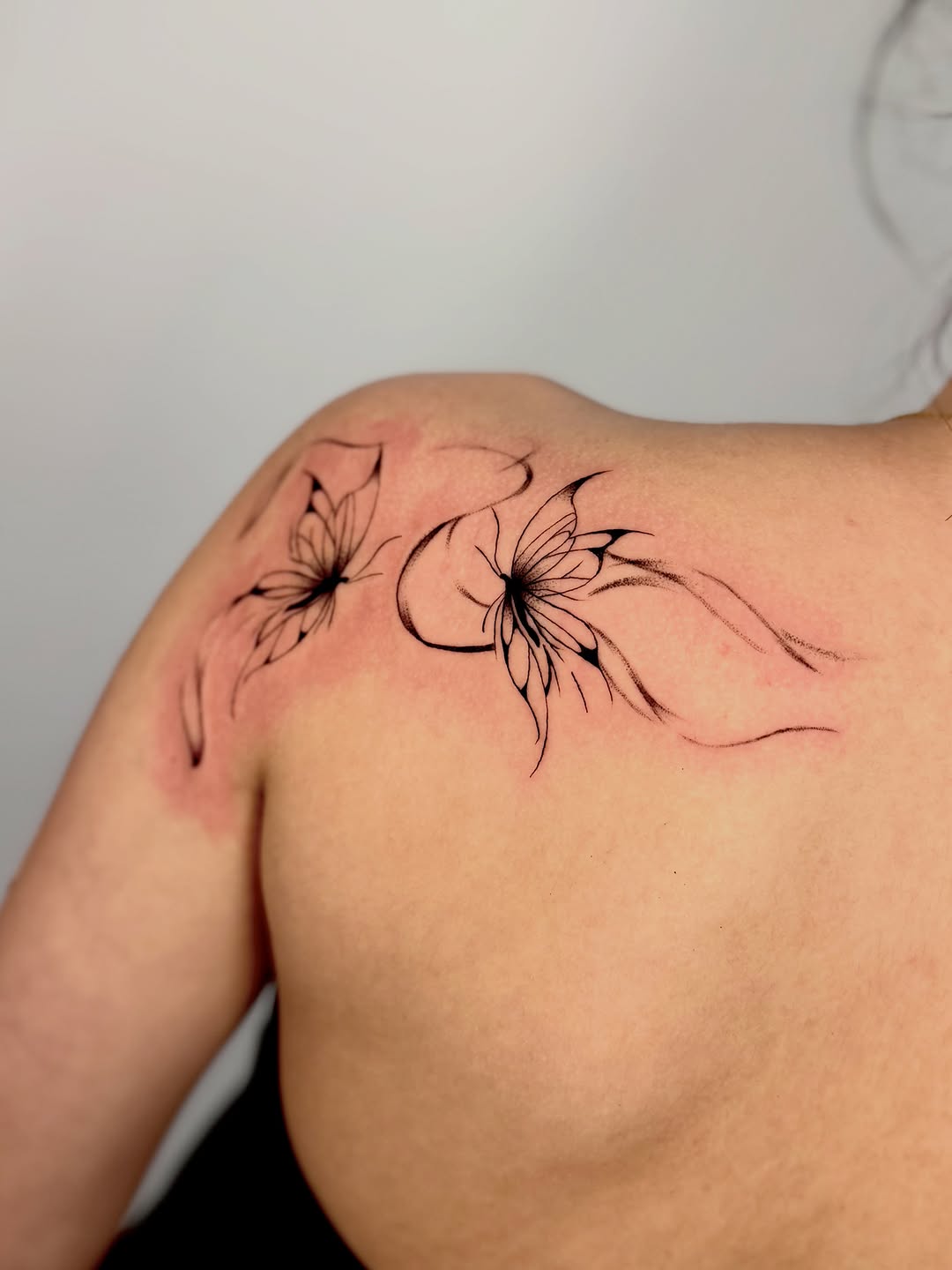 Butterflies fine line tattoo on the shoulder by Orca