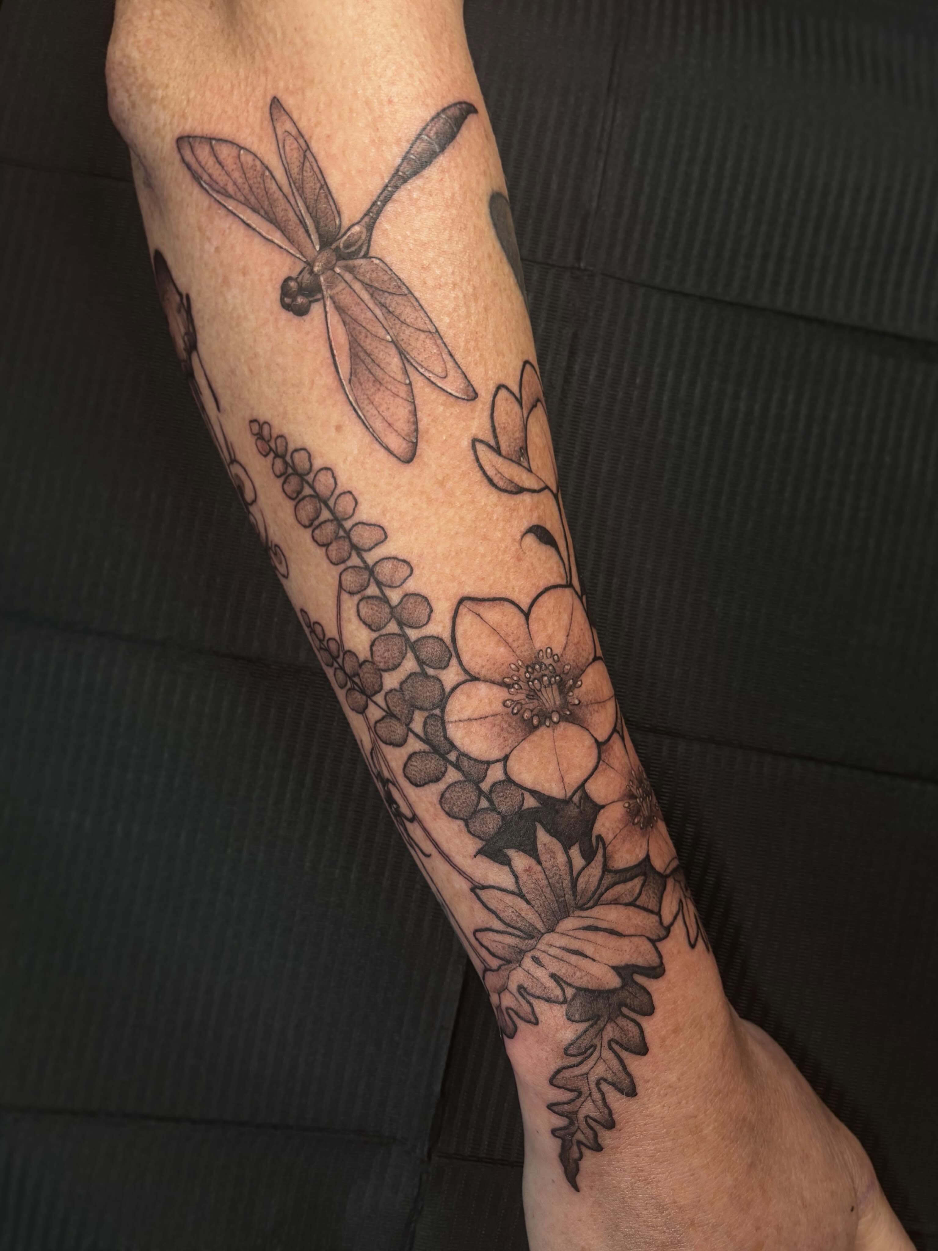 Dragonfly and floral arrangement realism tattoo on the forearm by Alex