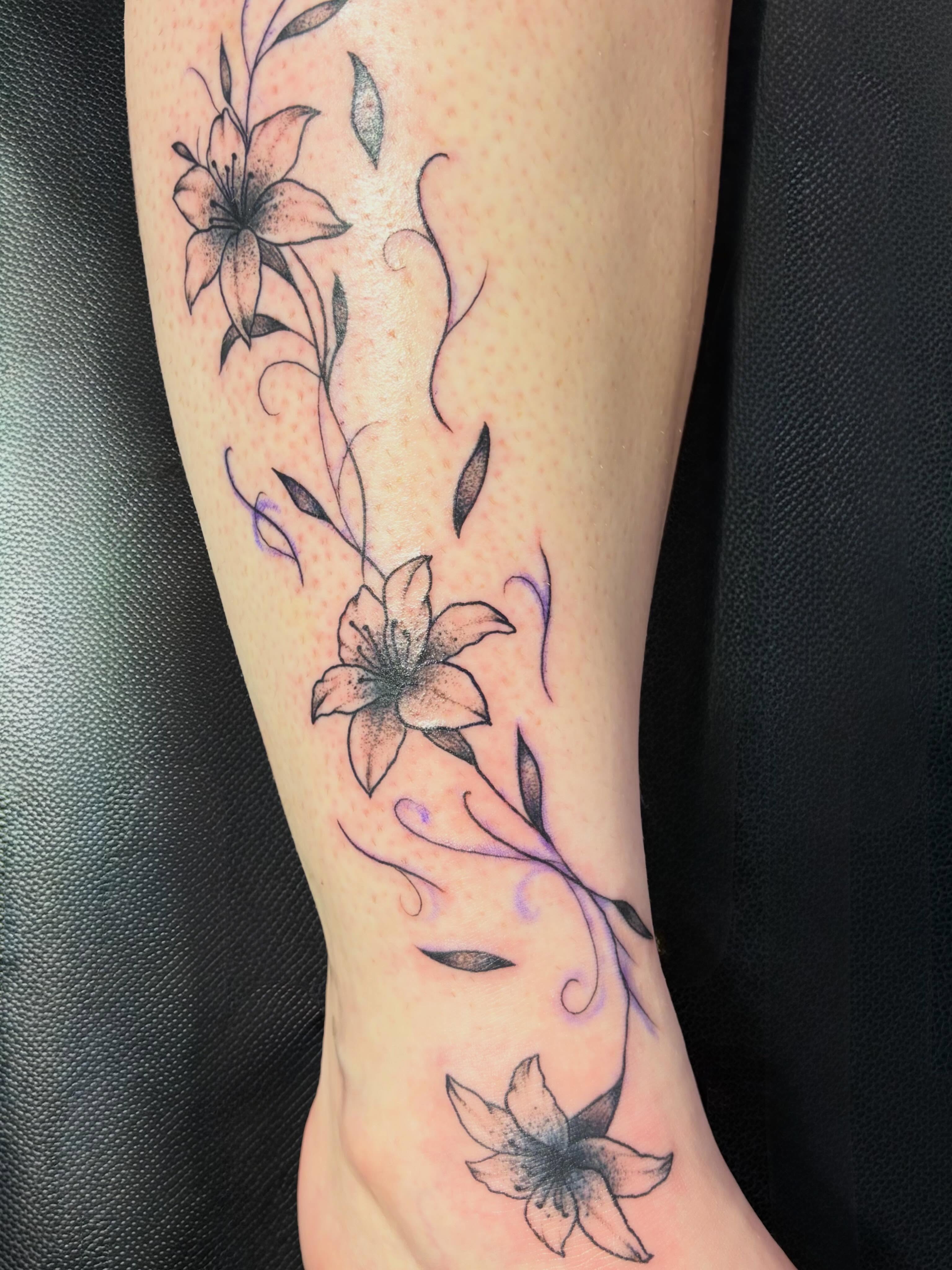 Lily flowers dotwork tattoo on the calf by Reid