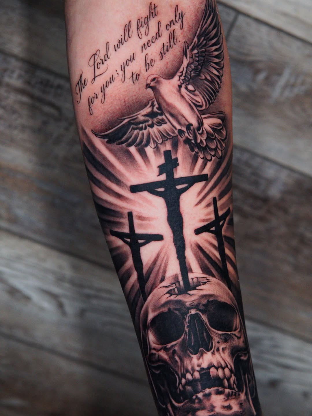 Skull, crosses, dove, and lettering Chicano tattoo on the forearm by Atlanta Tattoo Artist, Atlanta, Georgia