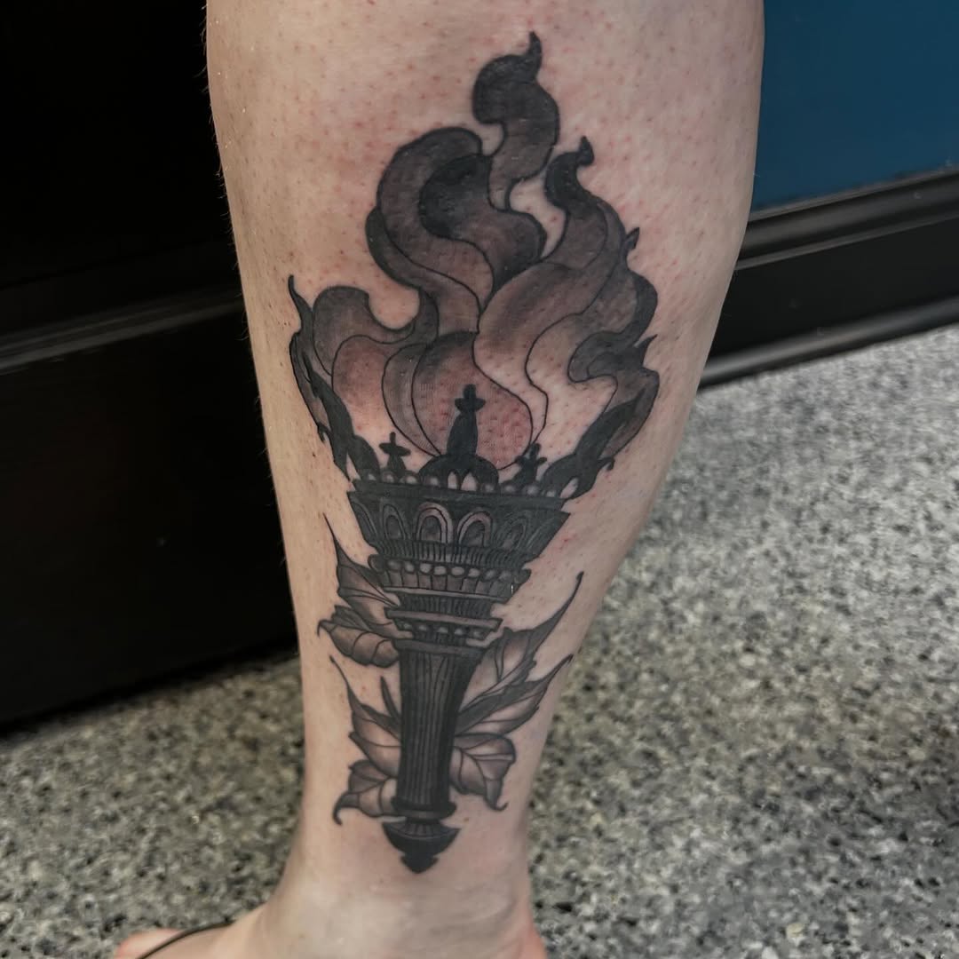 Torch with flames and leaves dark art tattoo on the calf by Gillian
