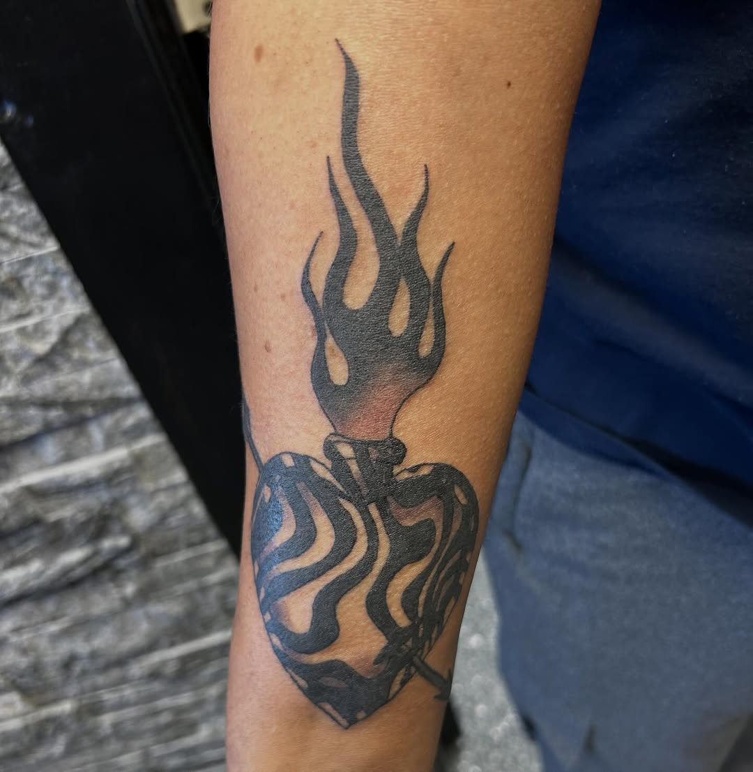 Flaming heart blackwork tattoo on the forearm by Gillian
