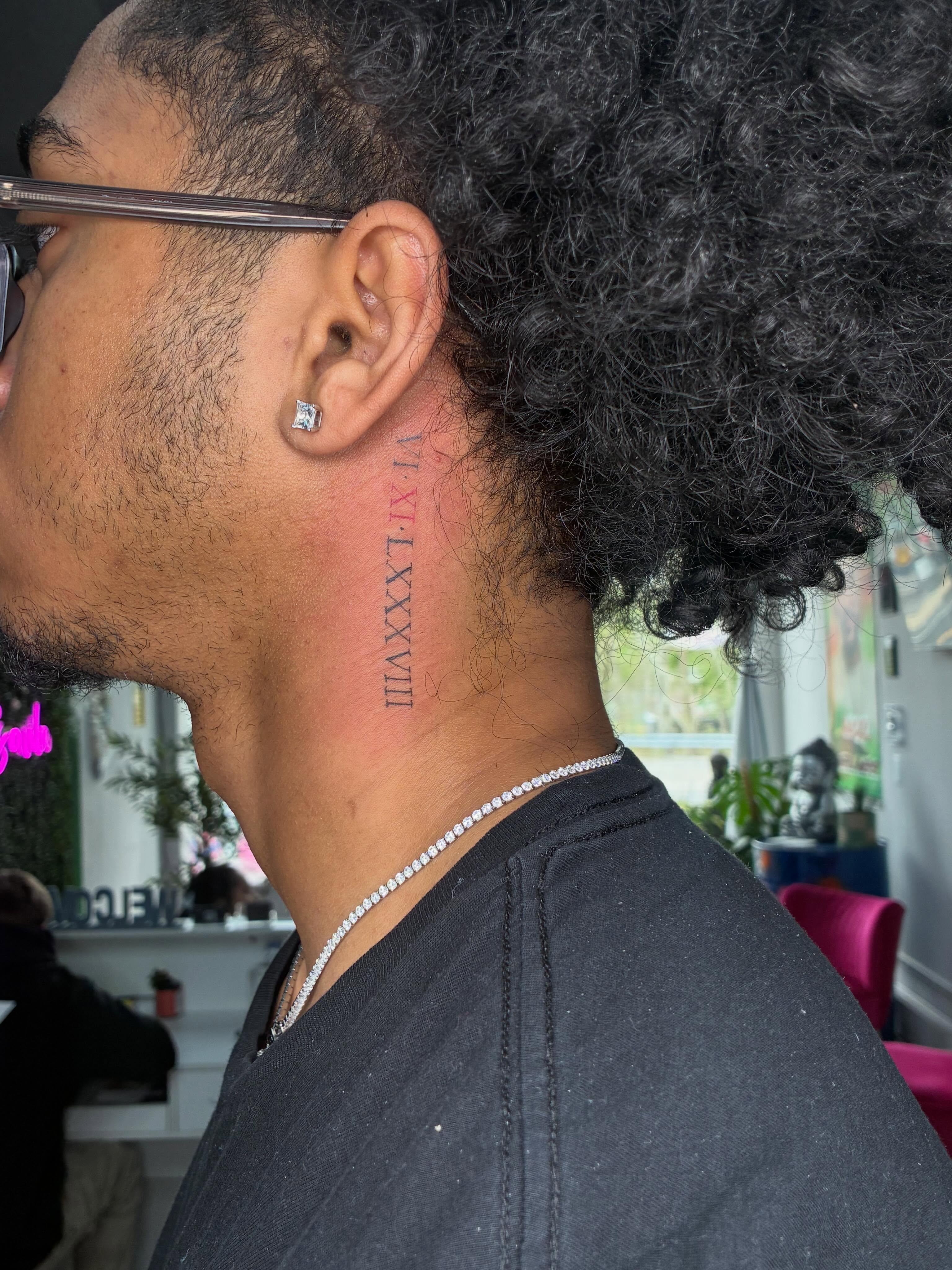 Roman numerals lettering script tattoo on the neck by Tattoos by Hailey
