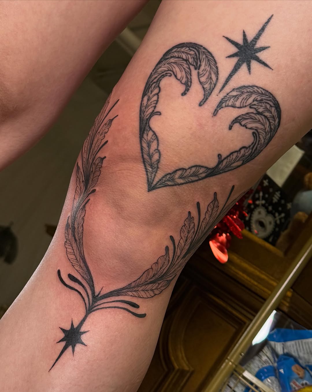 Heart with feathers black and grey tattoo on the forearm by Christian