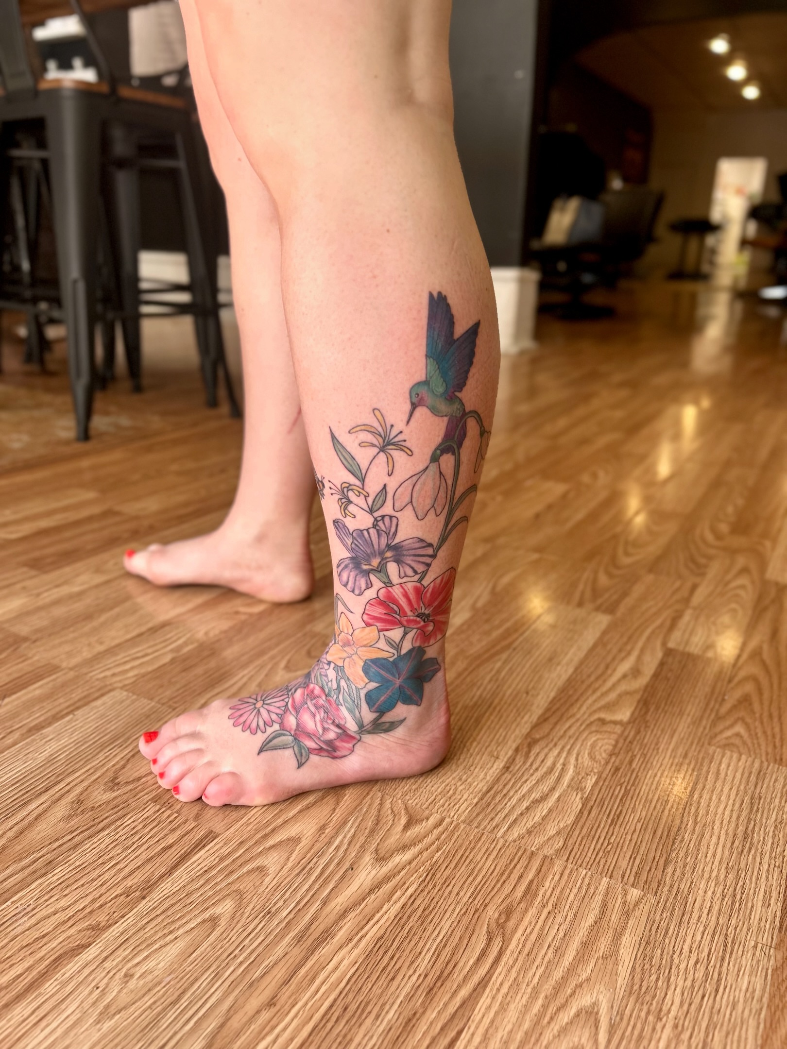 Bird and floral bouquet new school tattoo on the calf by Tori Magill