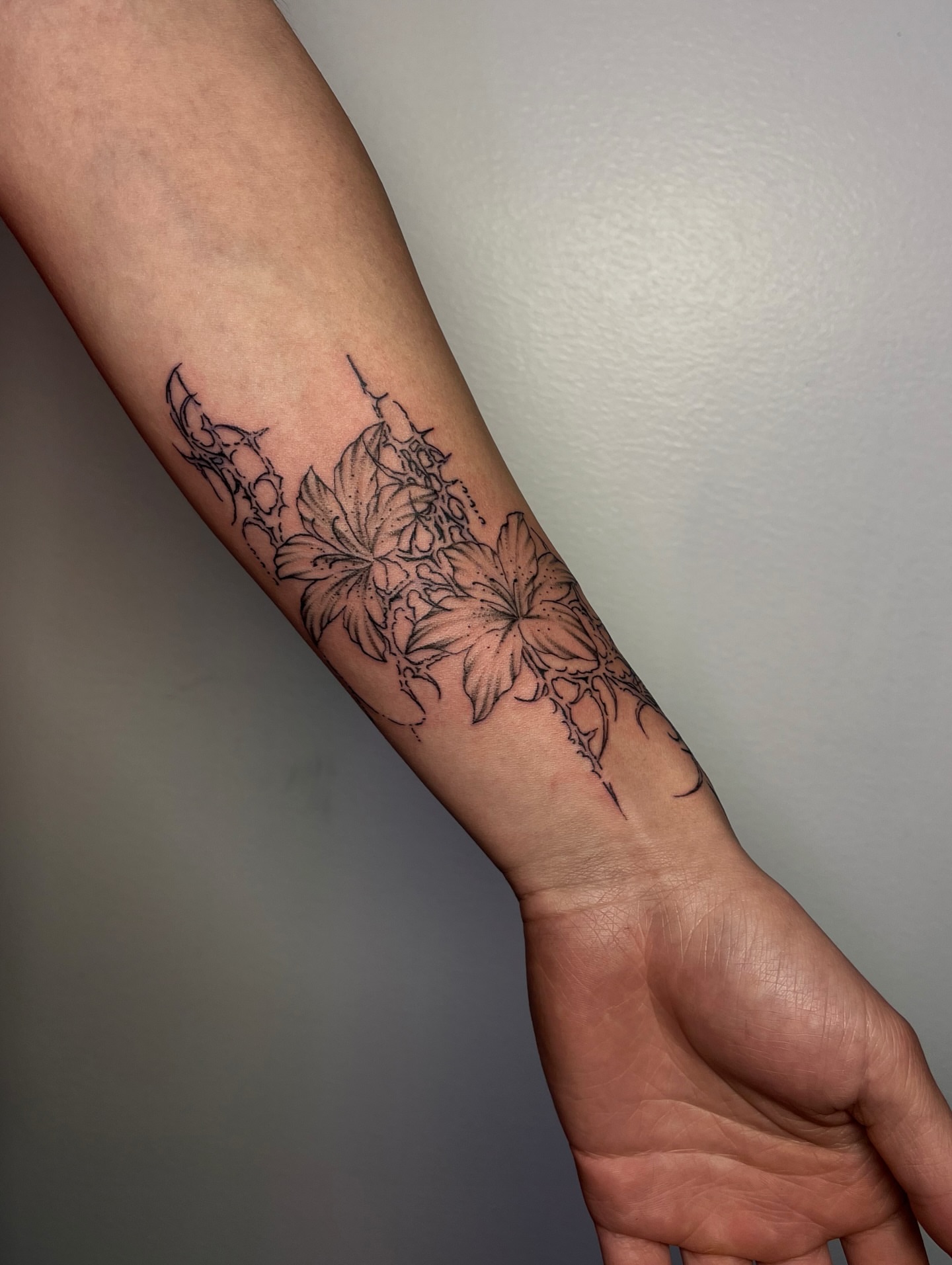 Floral arrangement black and grey tattoo on the forearm by MK