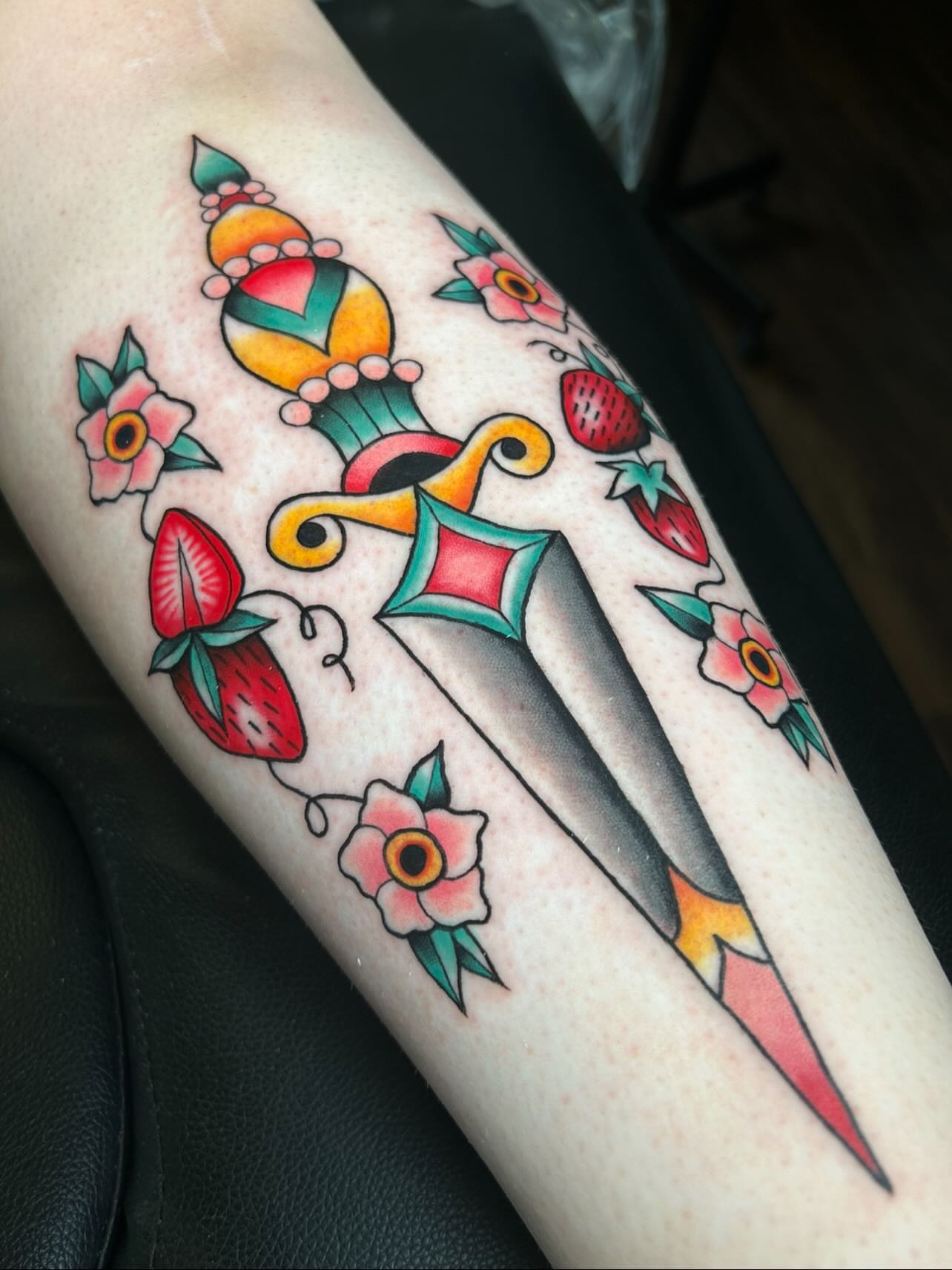 Sword and floral American traditional tattoo on the forearm by Vanessa Kendyll’s Tattoos