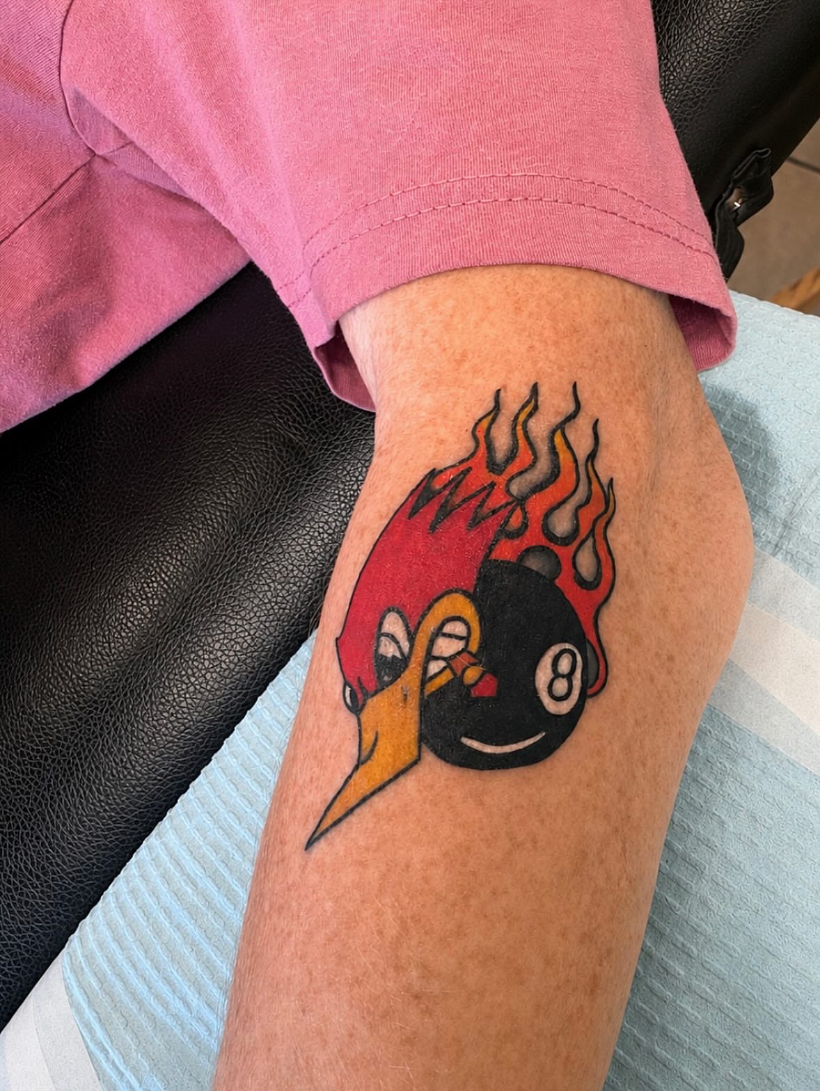 Flaming bird and eight ball American traditional tattoo on the forearm by Stoney