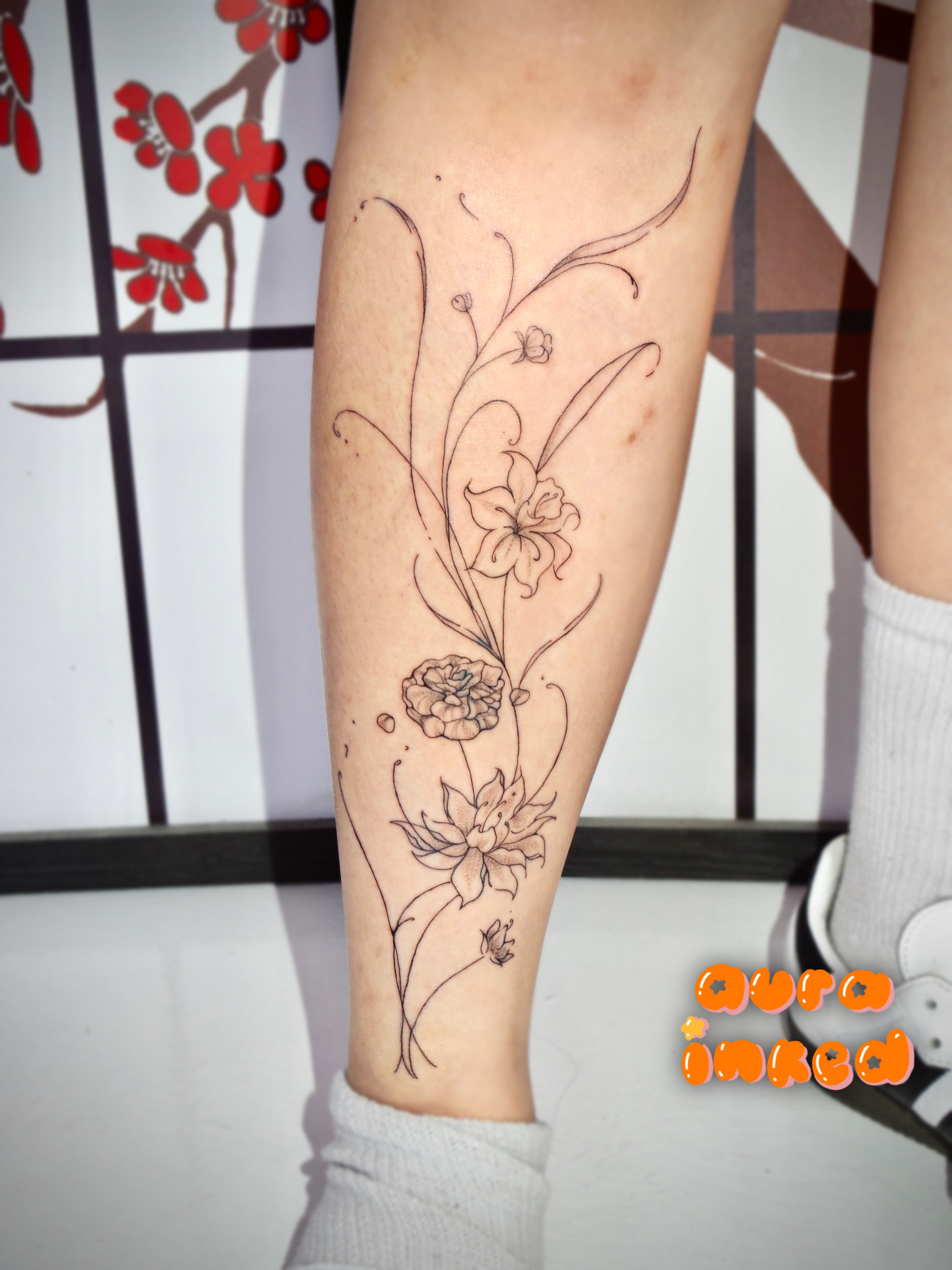 Floral arrangement fine line tattoo on the calf by Delly ⌯