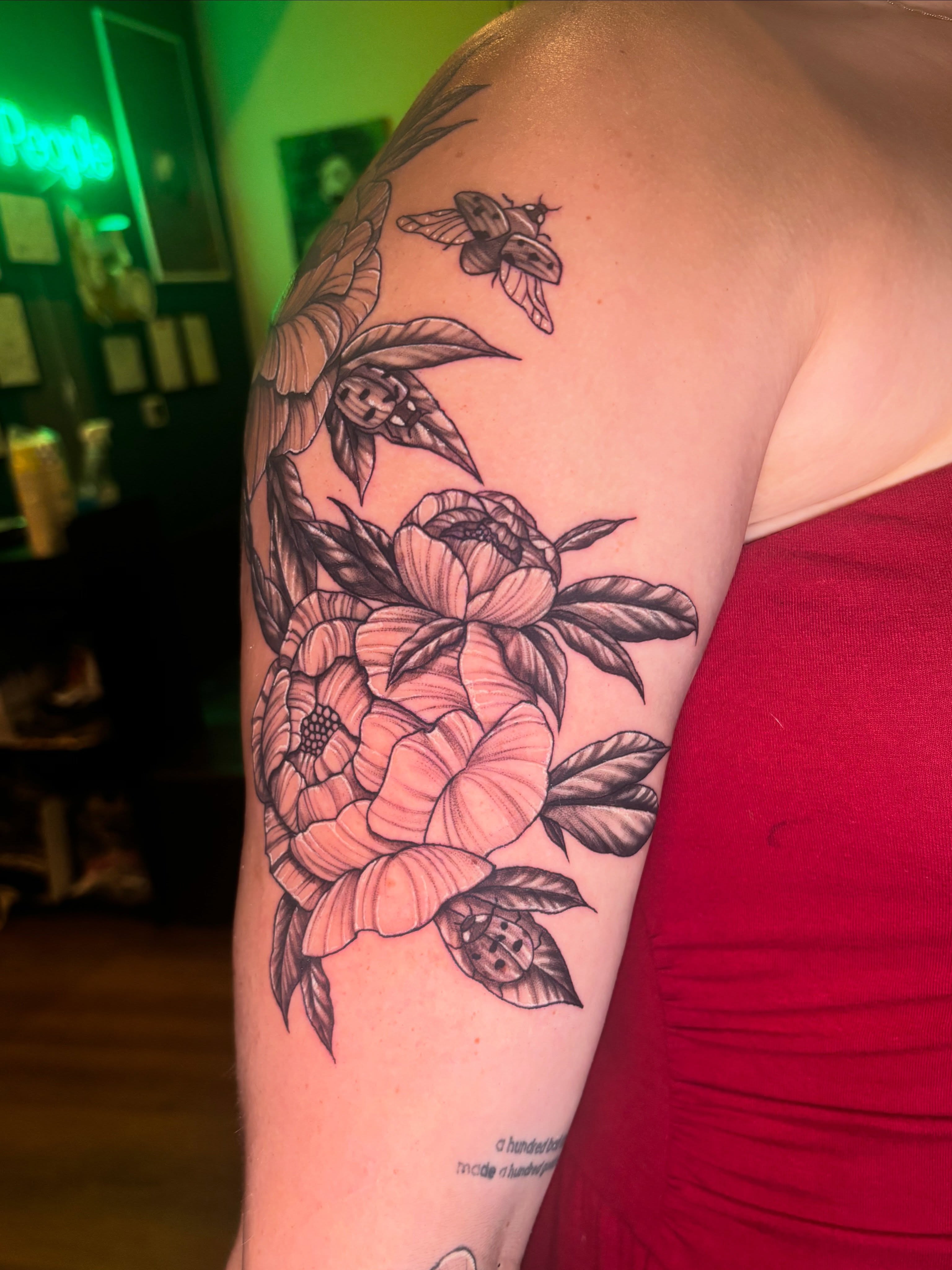 Peonies and insects neo-traditional tattoo on the upper arm by Kiwi🌱☀️