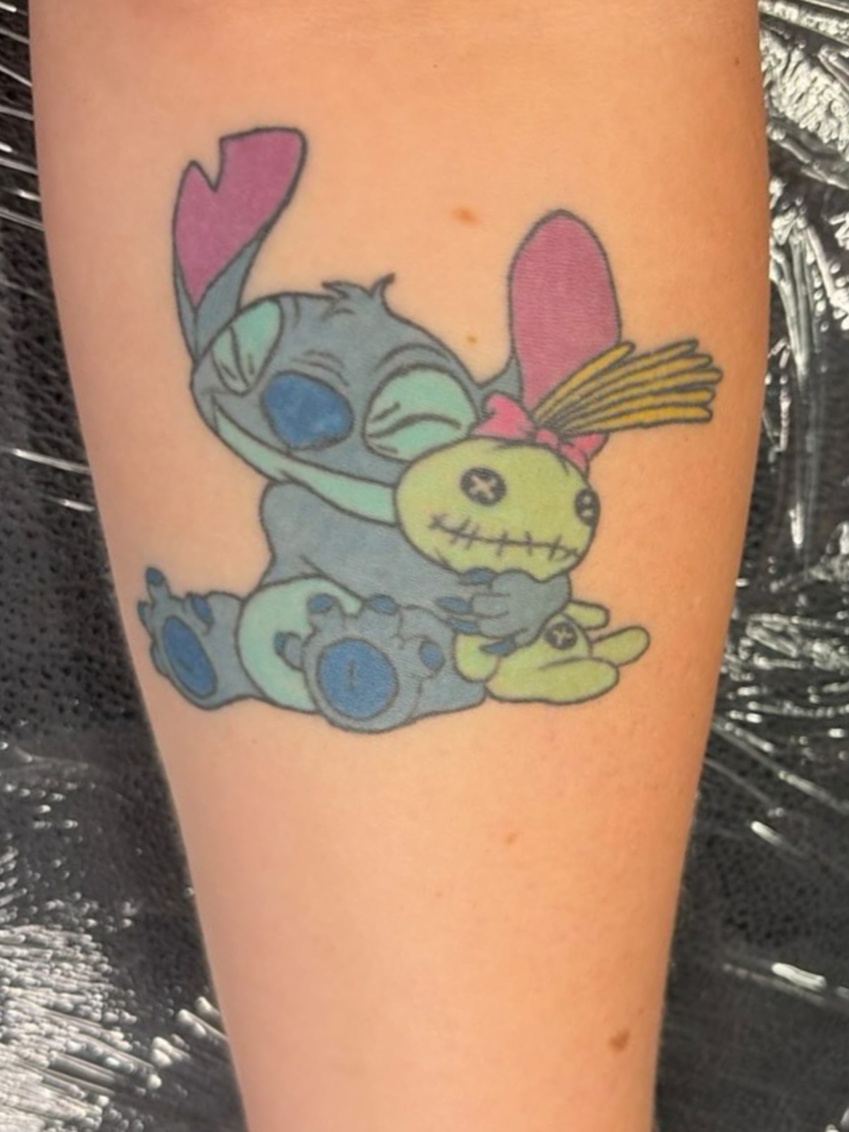 Stitch and skellington anime tattoo on the forearm by Brooke Sombati