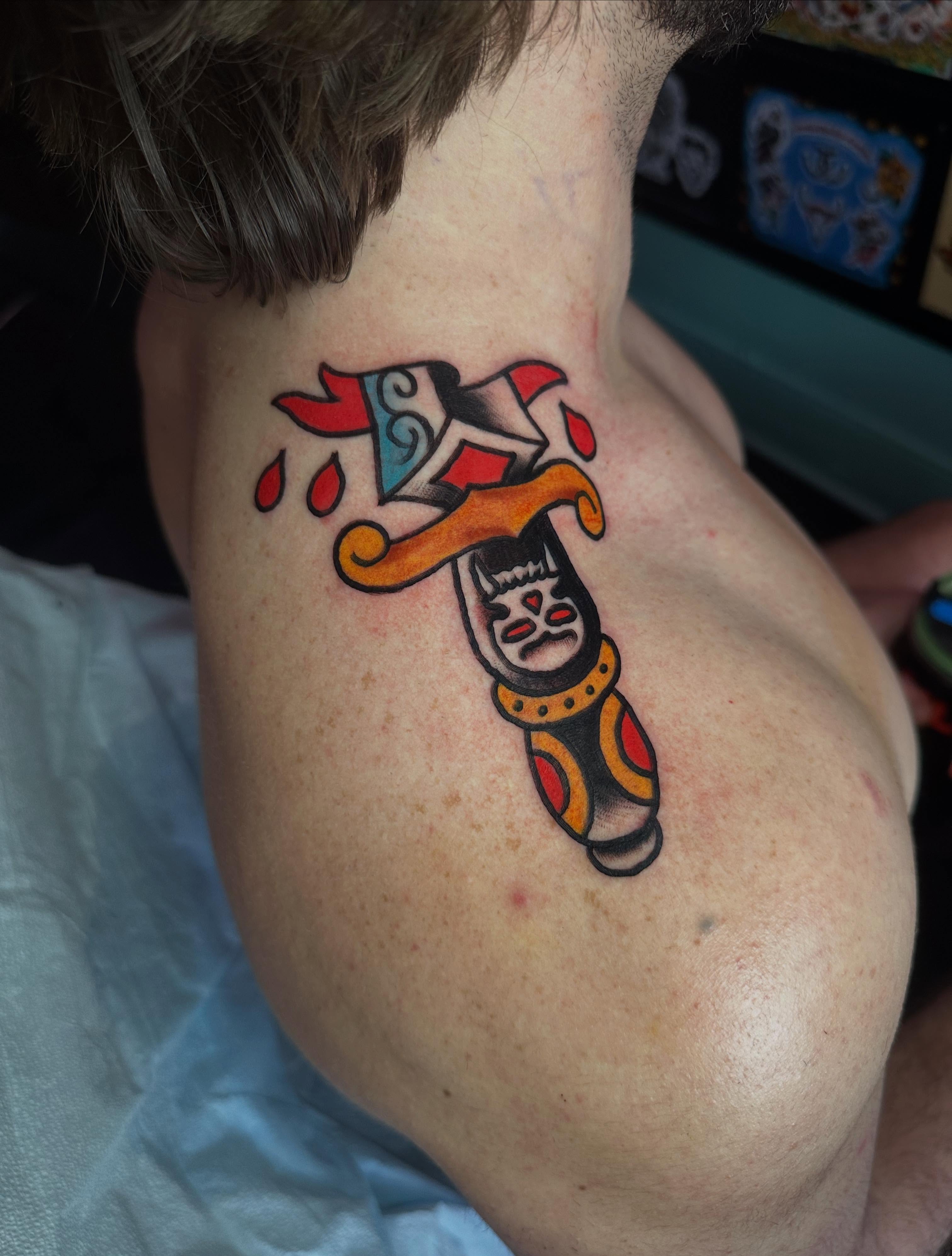 Jester mask American traditional tattoo on the shoulder by Chris Bishop
