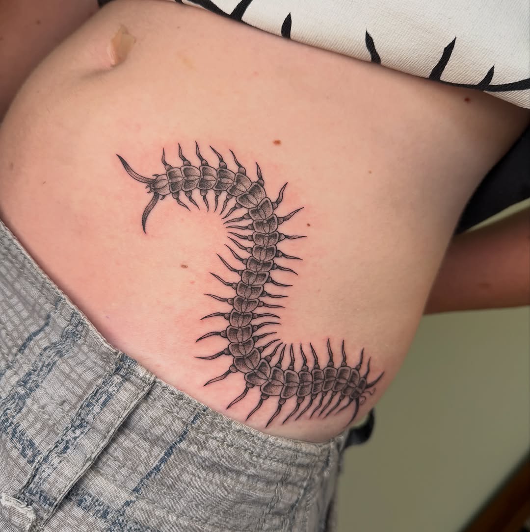 Centipede fine line tattoo on the thigh by Koryn Donnelly
