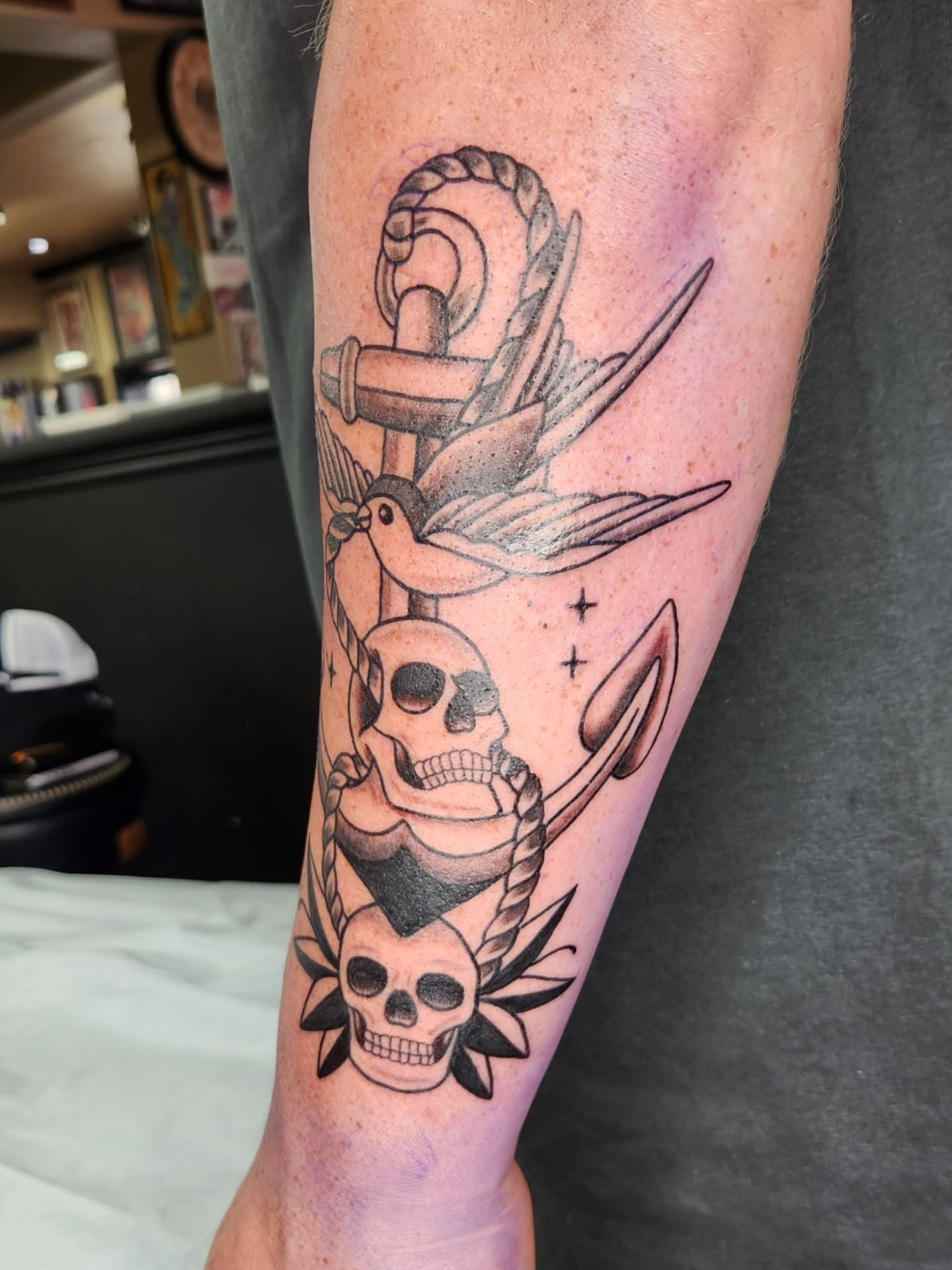 Anchor, bird, skulls American traditional tattoo on the forearm by Jessica Duggan
