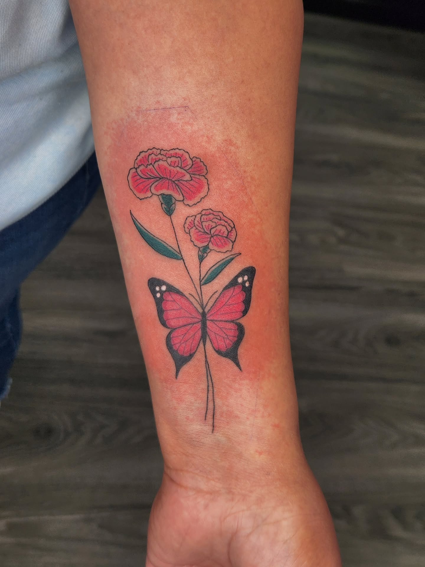 Butterfly and flowers new school tattoo on the forearm by Jessica Duggan