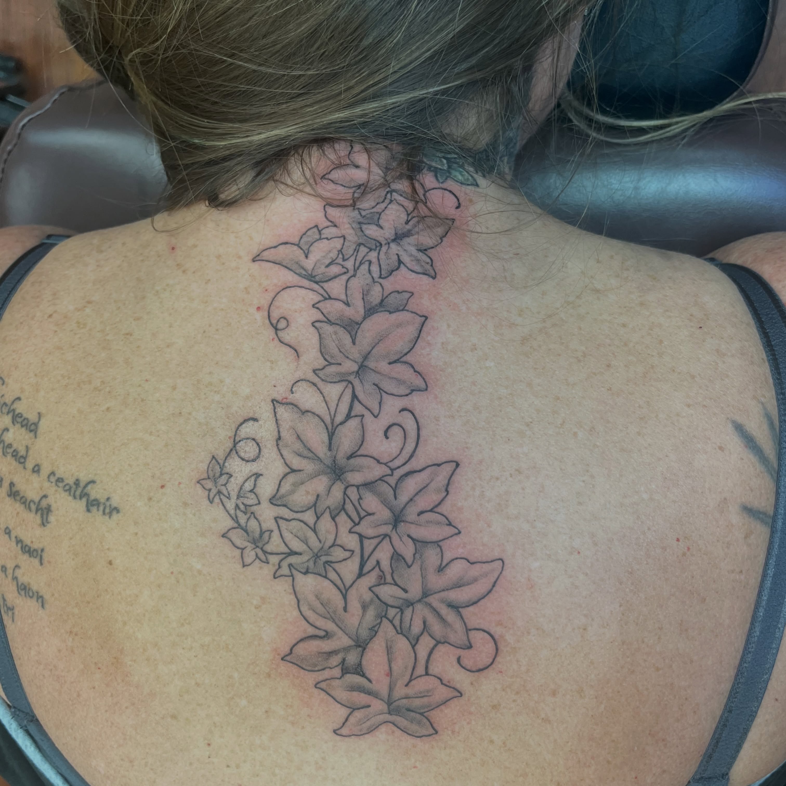 Flower vine black and grey tattoo on the back by Caito Conner