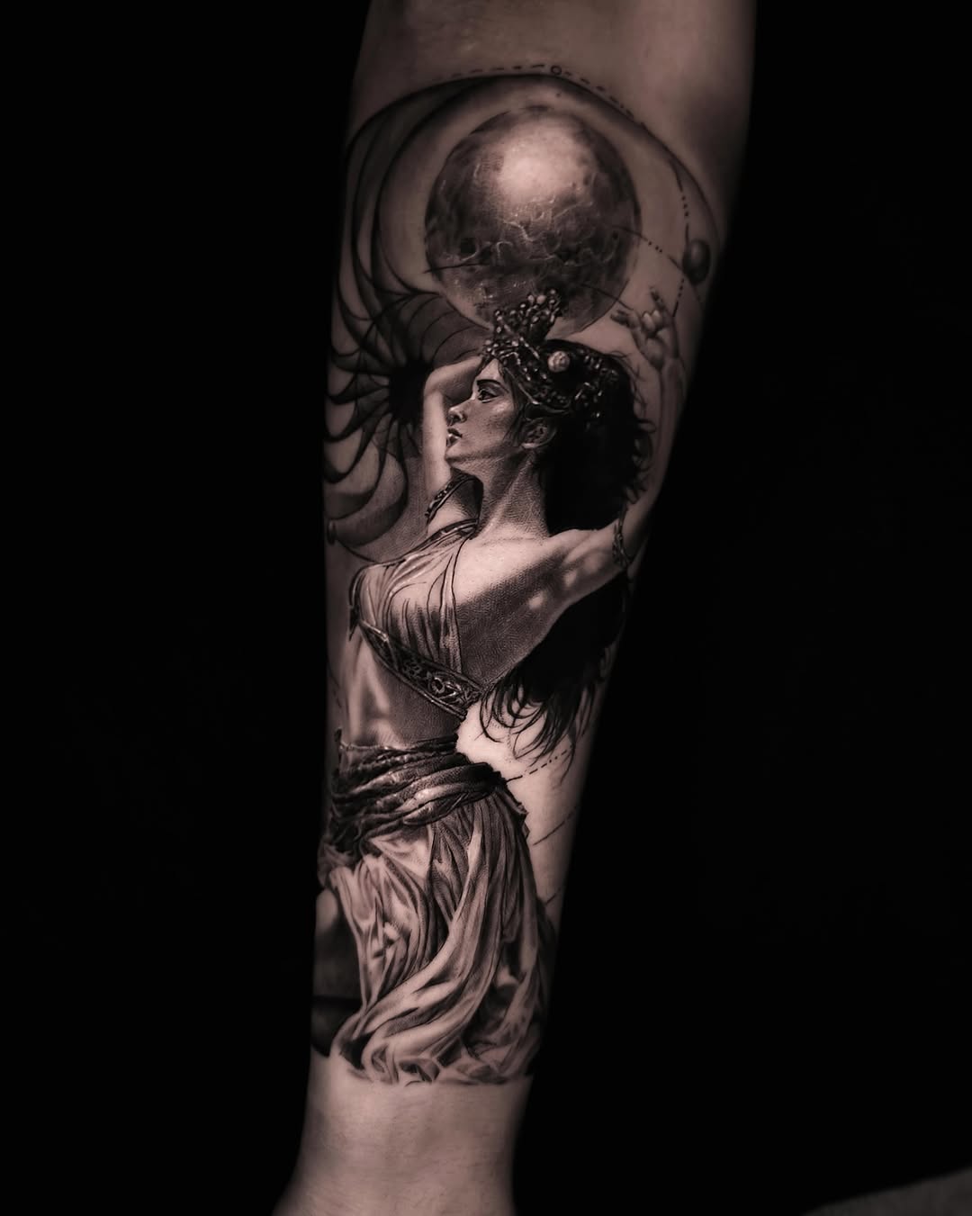Woman holding a planet realism tattoo on the forearm by Pitasso tattoo black and grey