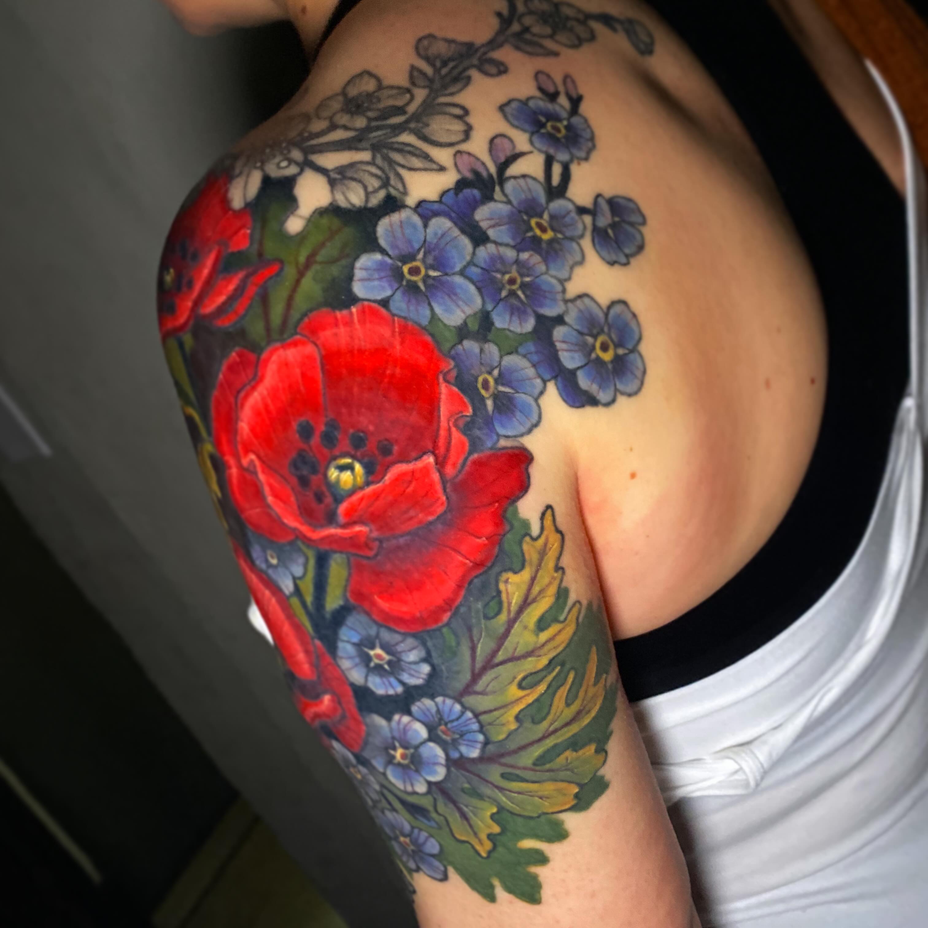 Poppy and forget-me-nots new school tattoo on the shoulder by Lindsay Hall