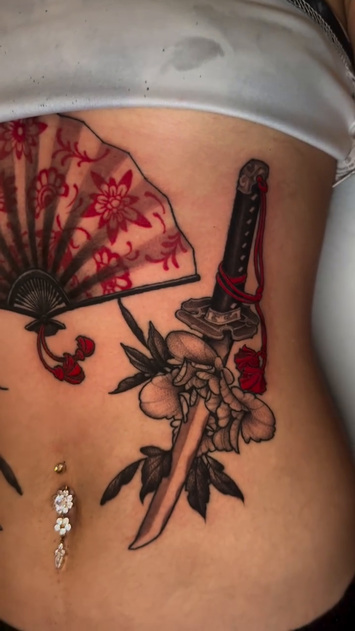 Japanese fan with swords and flowers American traditional tattoo on the torso by Mike Nance