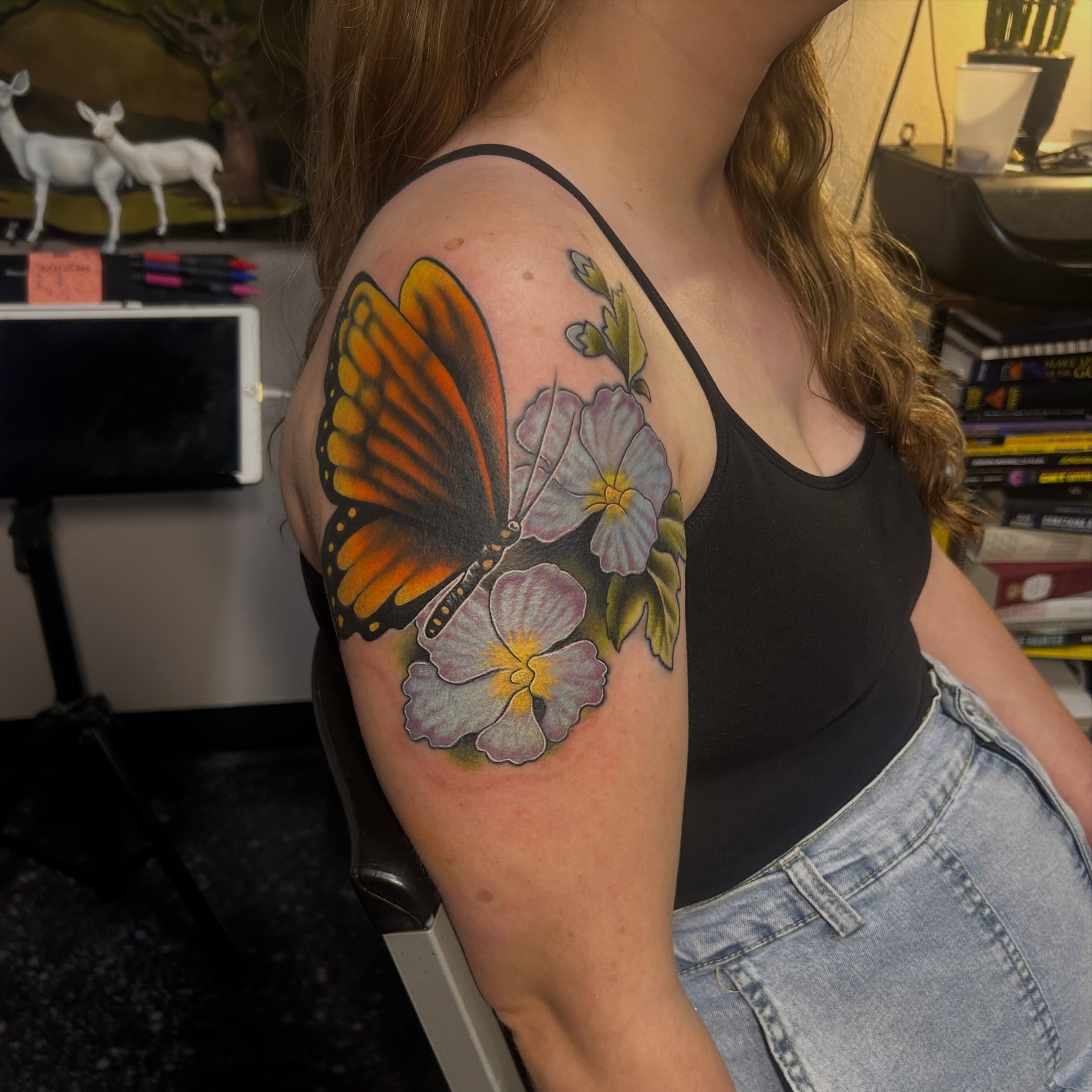 Monarch butterfly and flowers realism tattoo on the upper arm by Jamie Winn