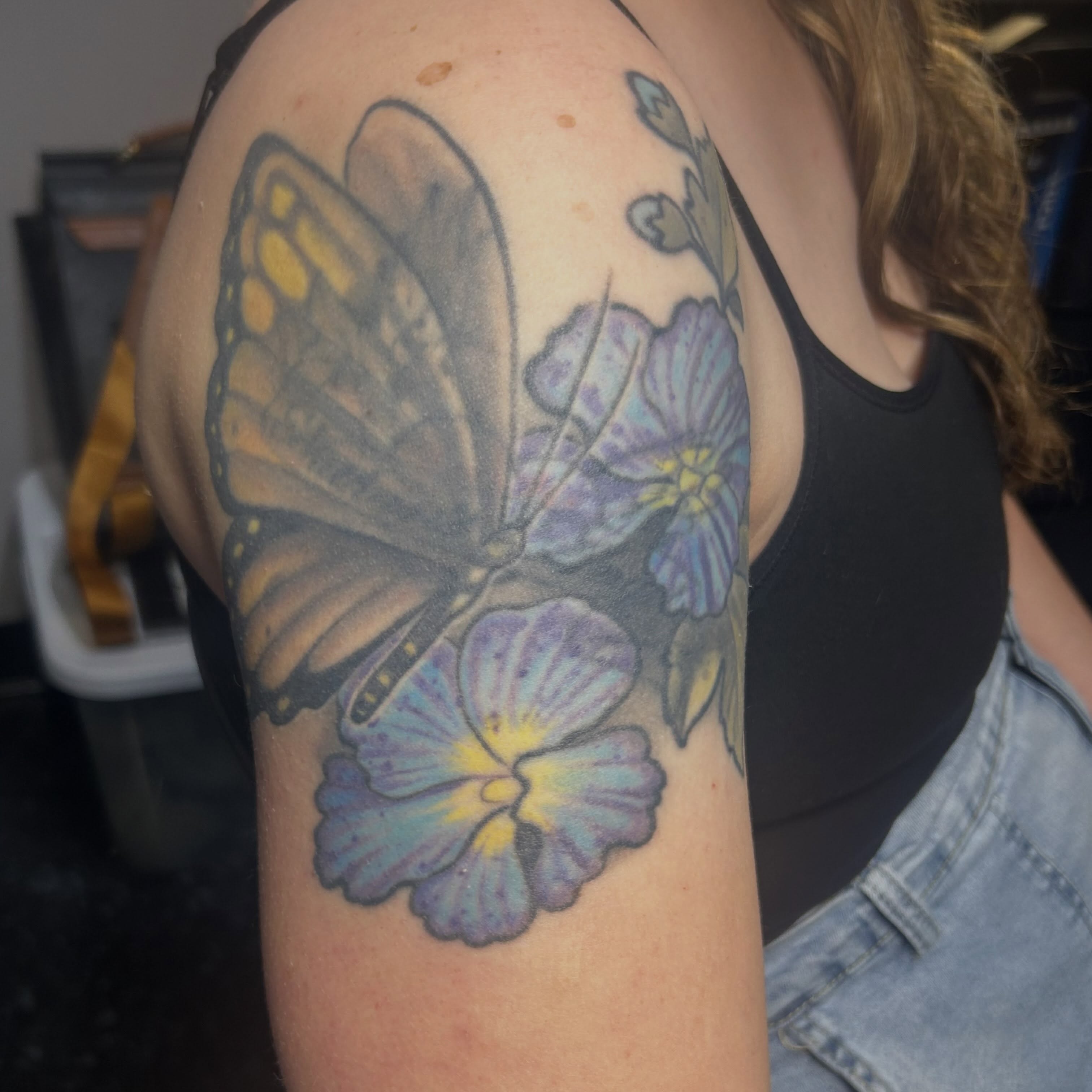 Butterfly and flowers realism tattoo on the shoulder by Jamie Winn