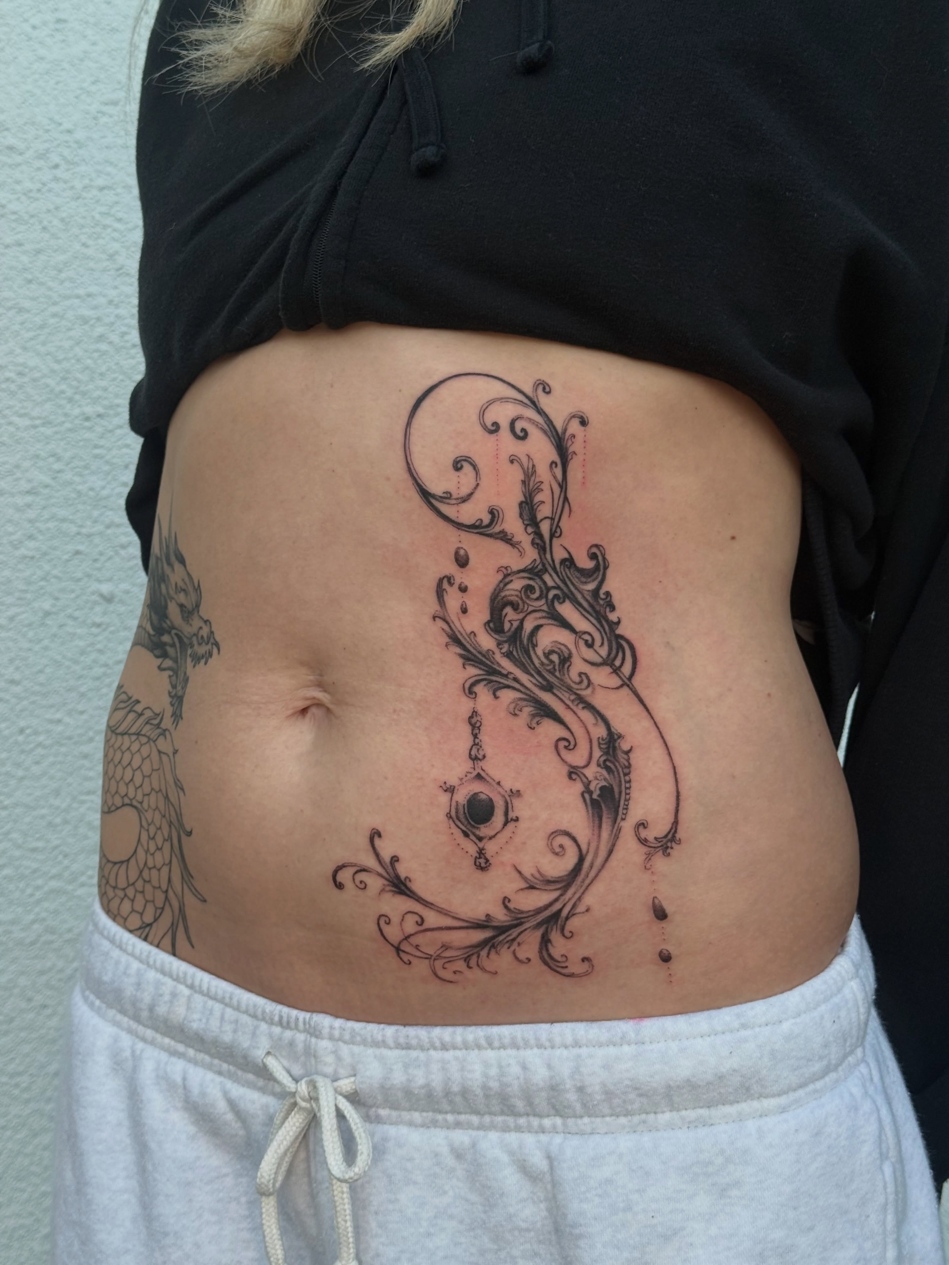 Scrollwork ornamental tattoo on the torso by Ava Nilou
