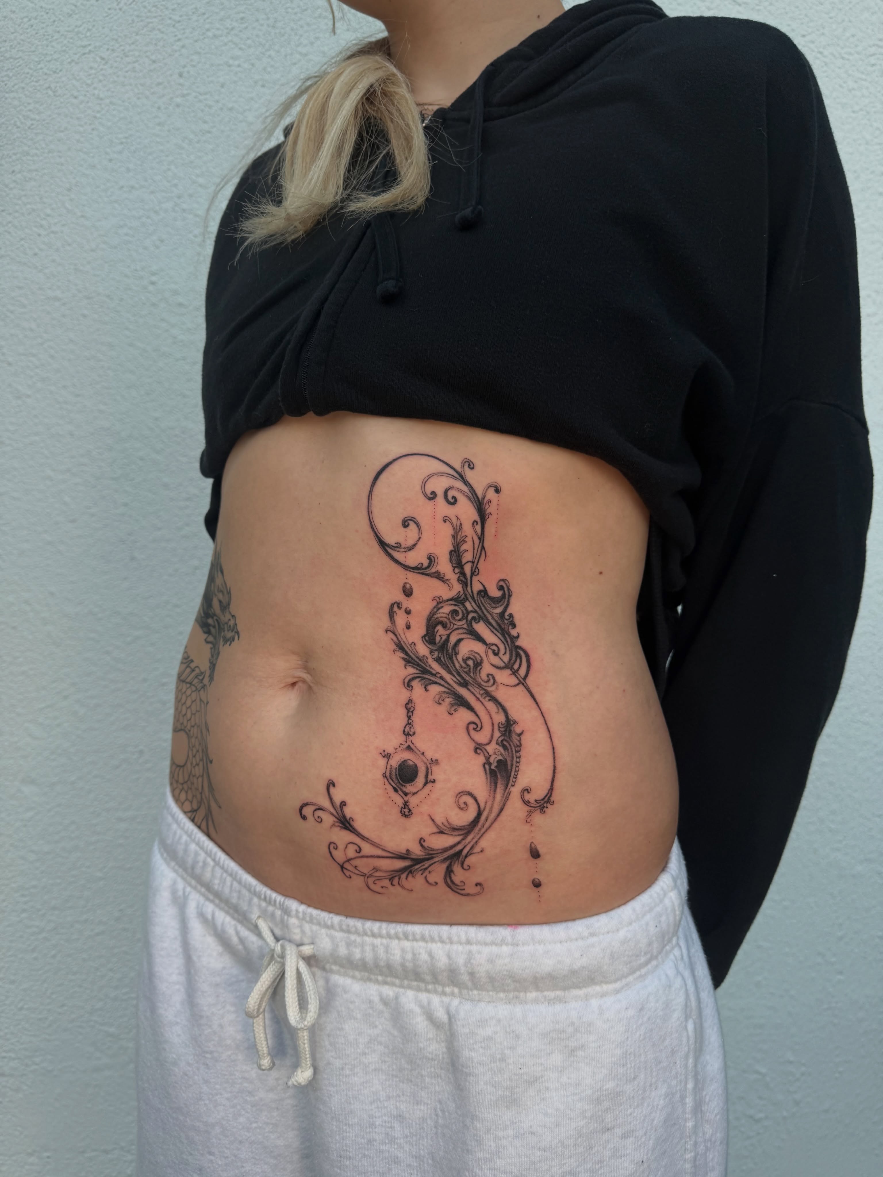 Scrollwork ornamental tattoo on the torso by Ava Nilou