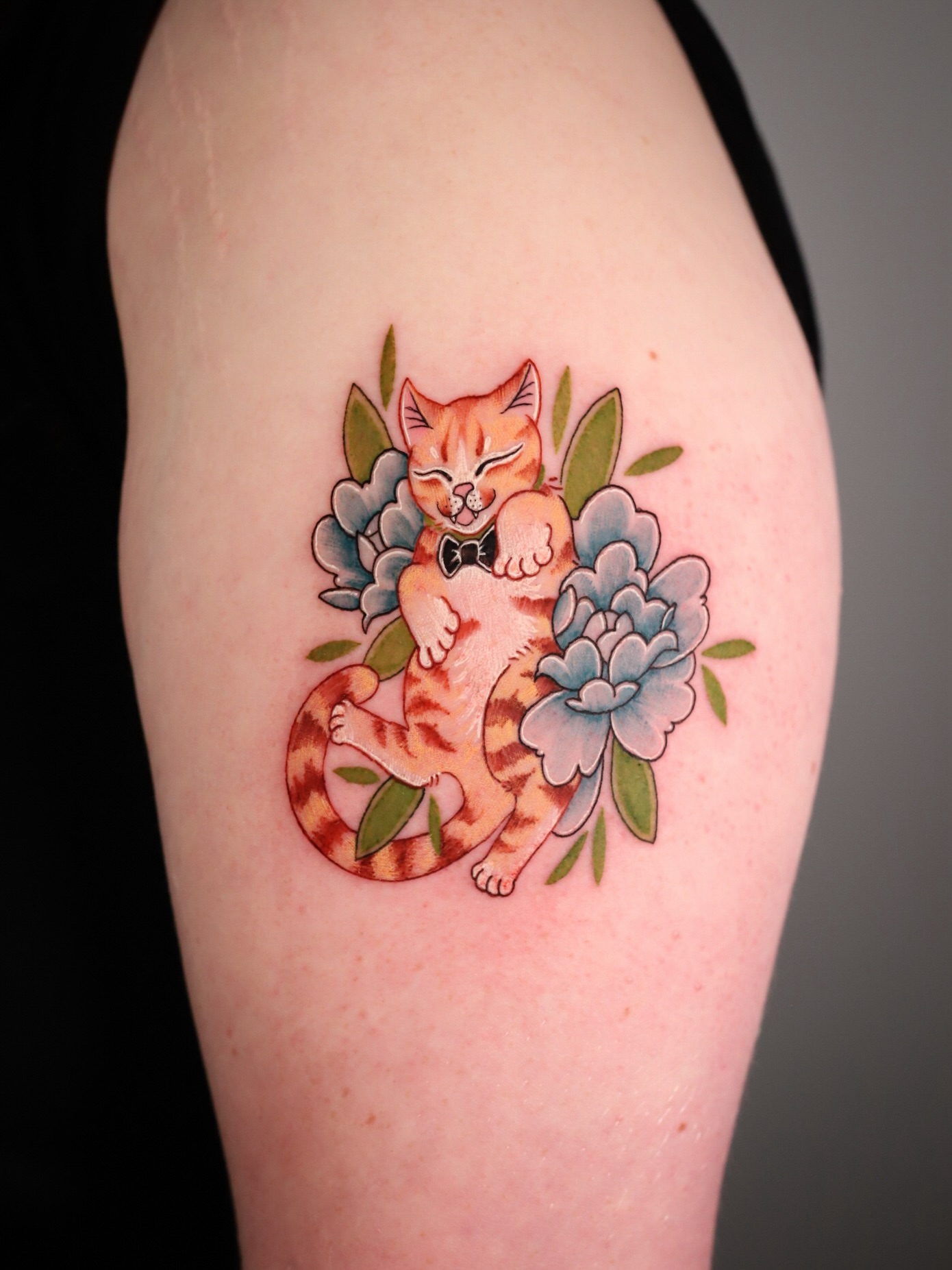 Cat with flowers American traditional tattoo on the upper arm by Stephanie Shortsleeve