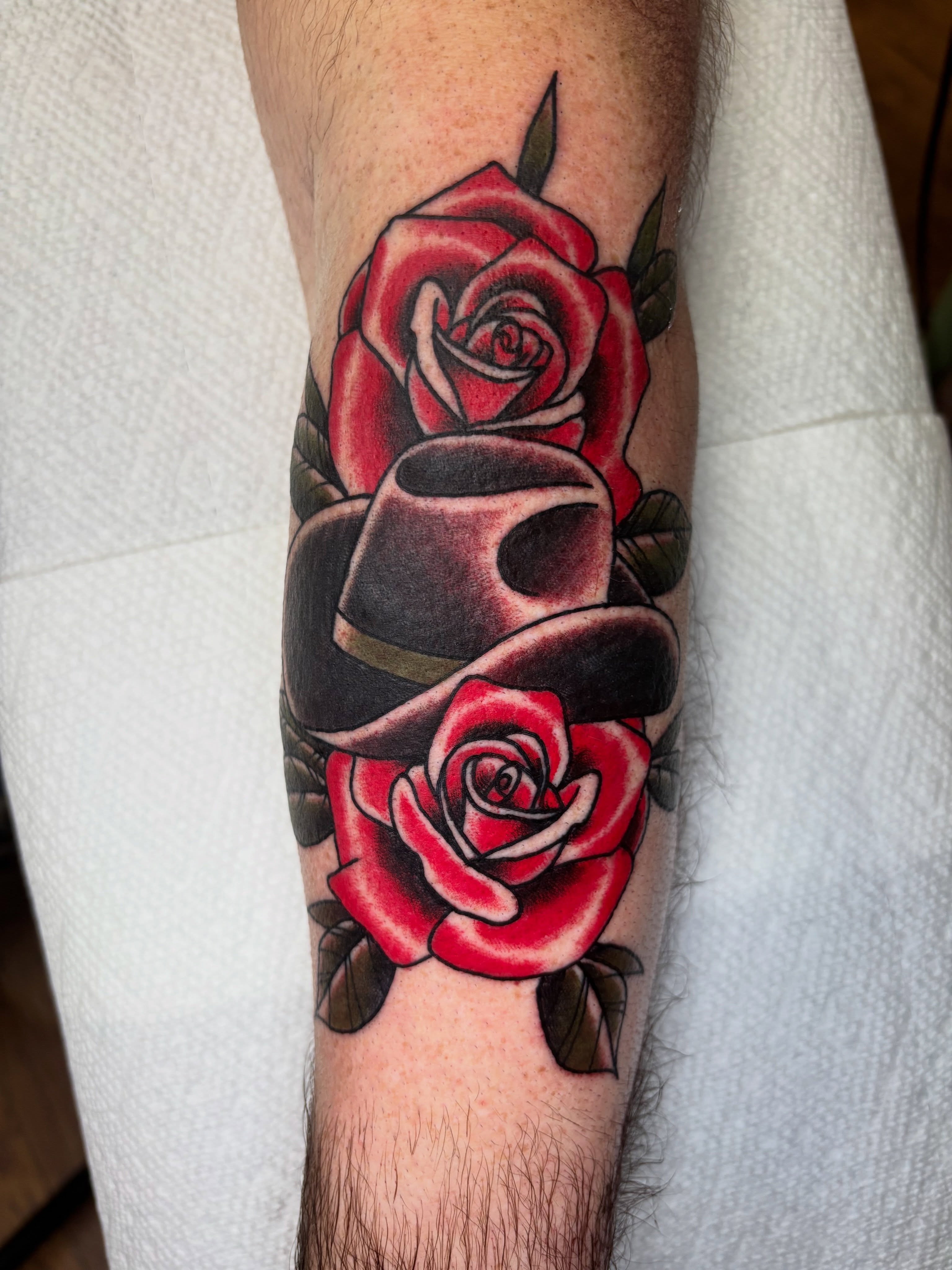 Red roses and hat American traditional tattoo on the forearm by AARON MASTERS - Tattoo Artist