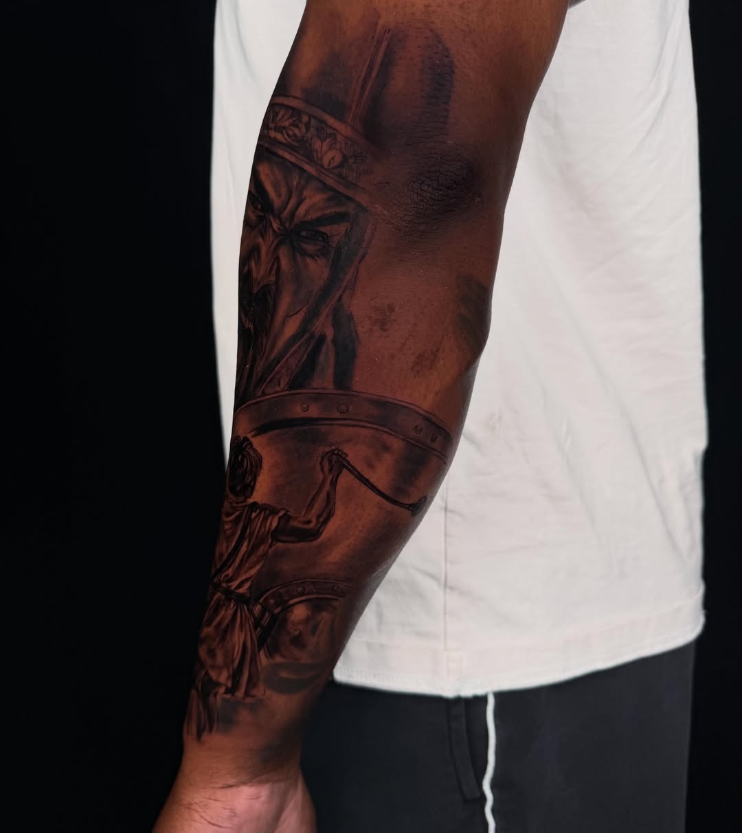 Warrior helmet and shield realism tattoo on the forearm by Idalia Pulido