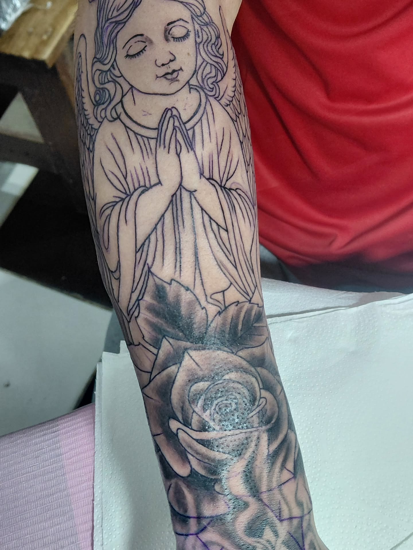 Praying angel with rose black and grey tattoo on the forearm by Jose Rodriguez