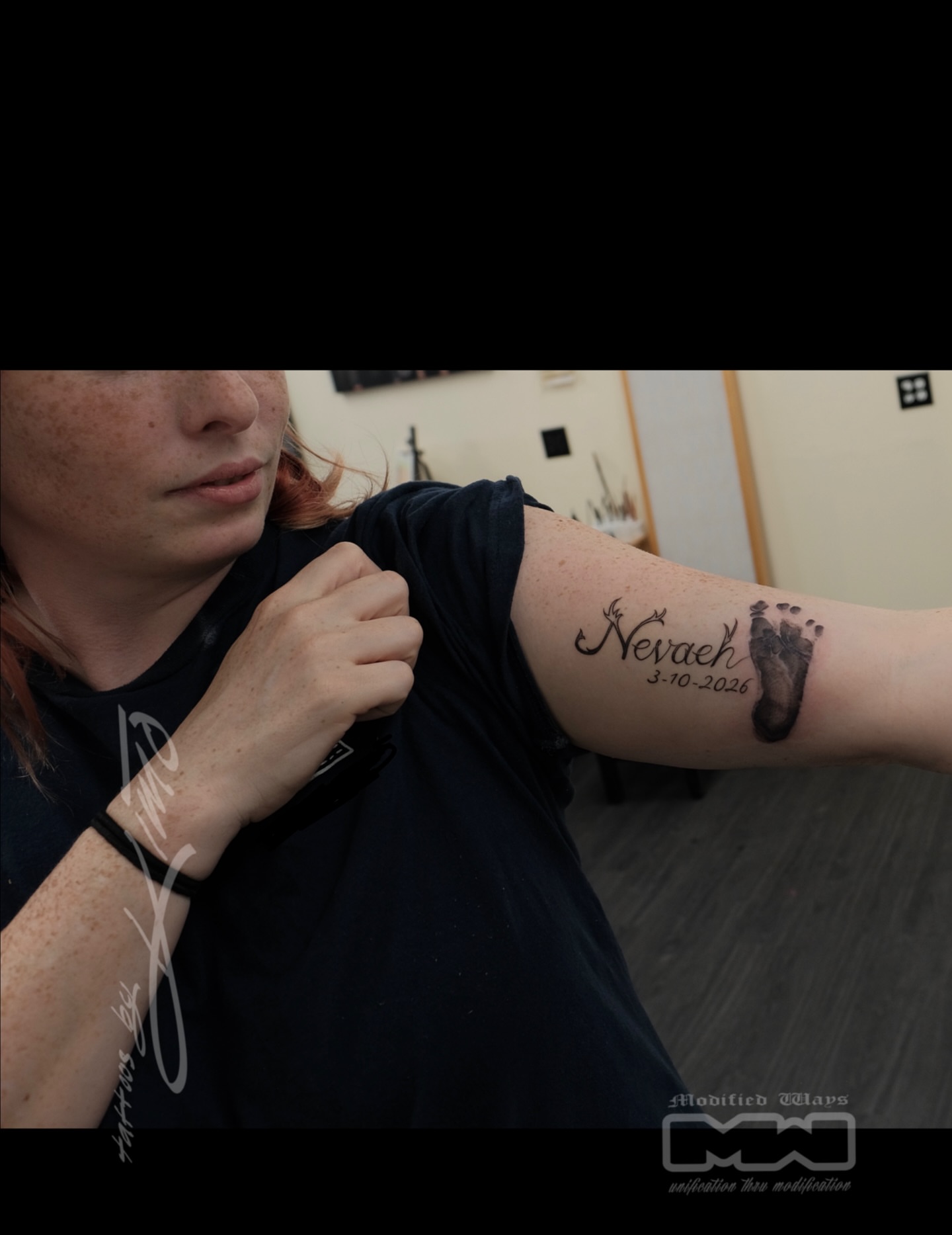 Baby footprint and name black and grey tattoo on the forearm by Kansas City tattoo artist