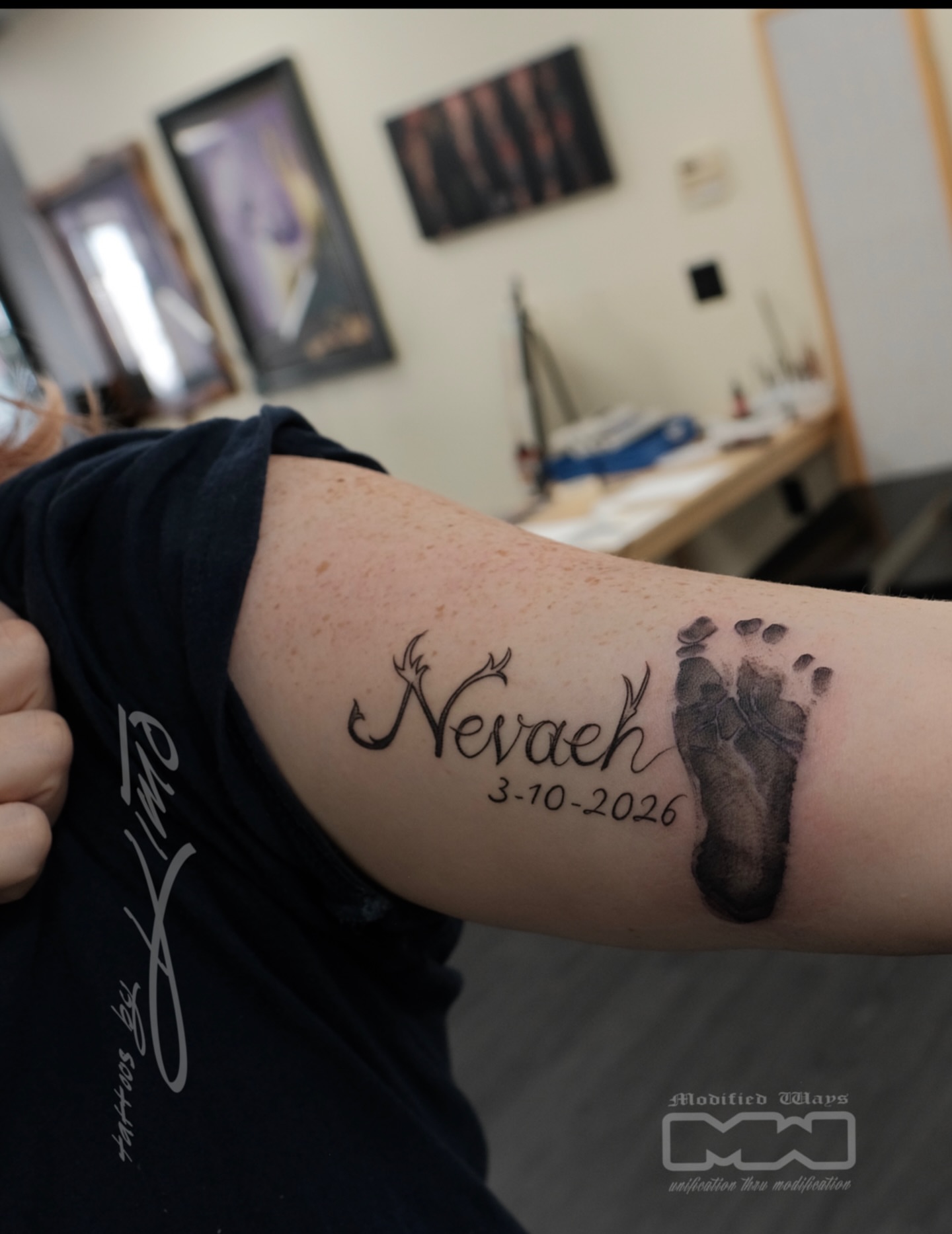 Baby footprint black and grey tattoo on the forearm by Kansas City tattoo artist