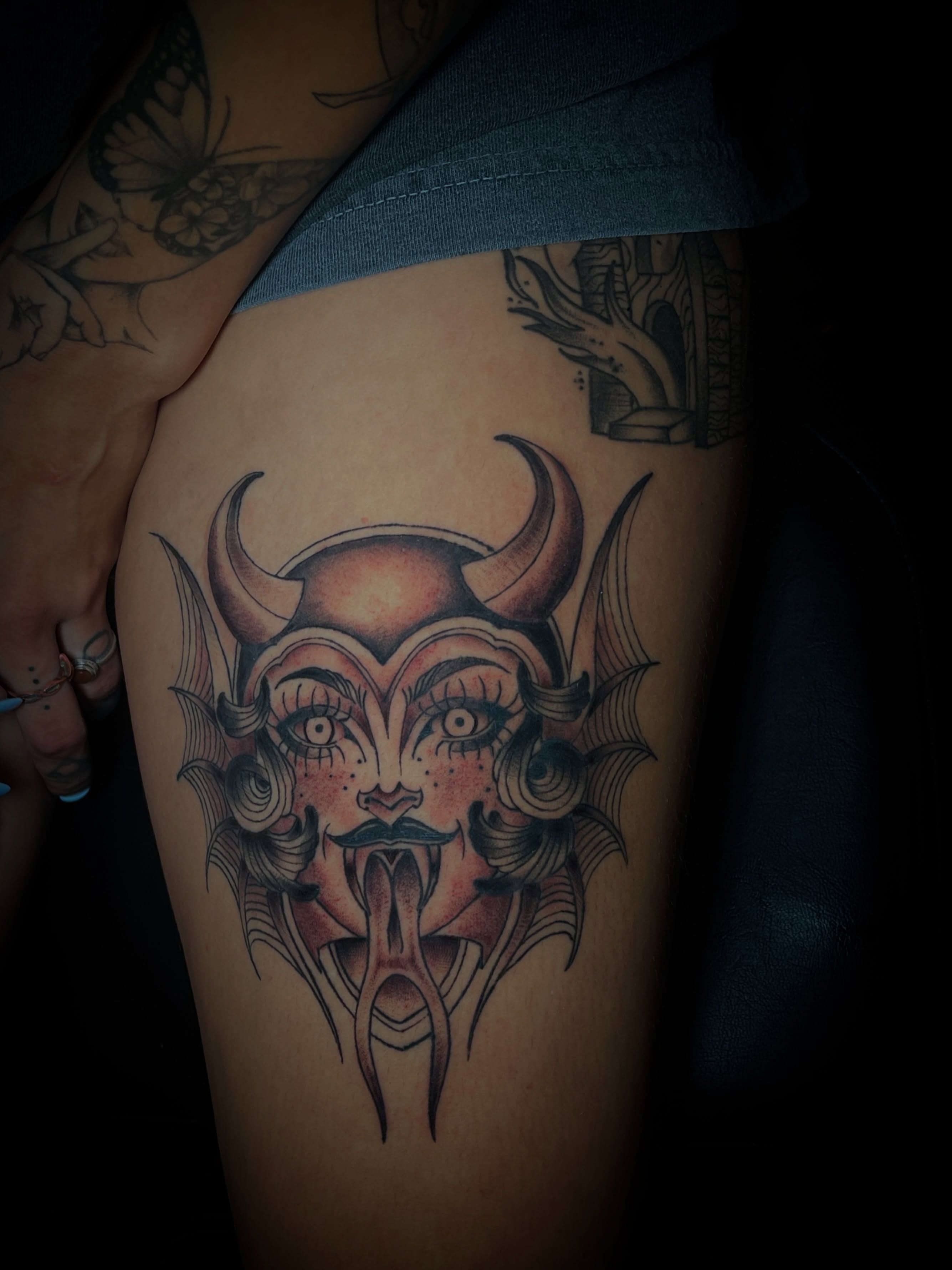 Demon face American traditional tattoo on the thigh by MoogieTats