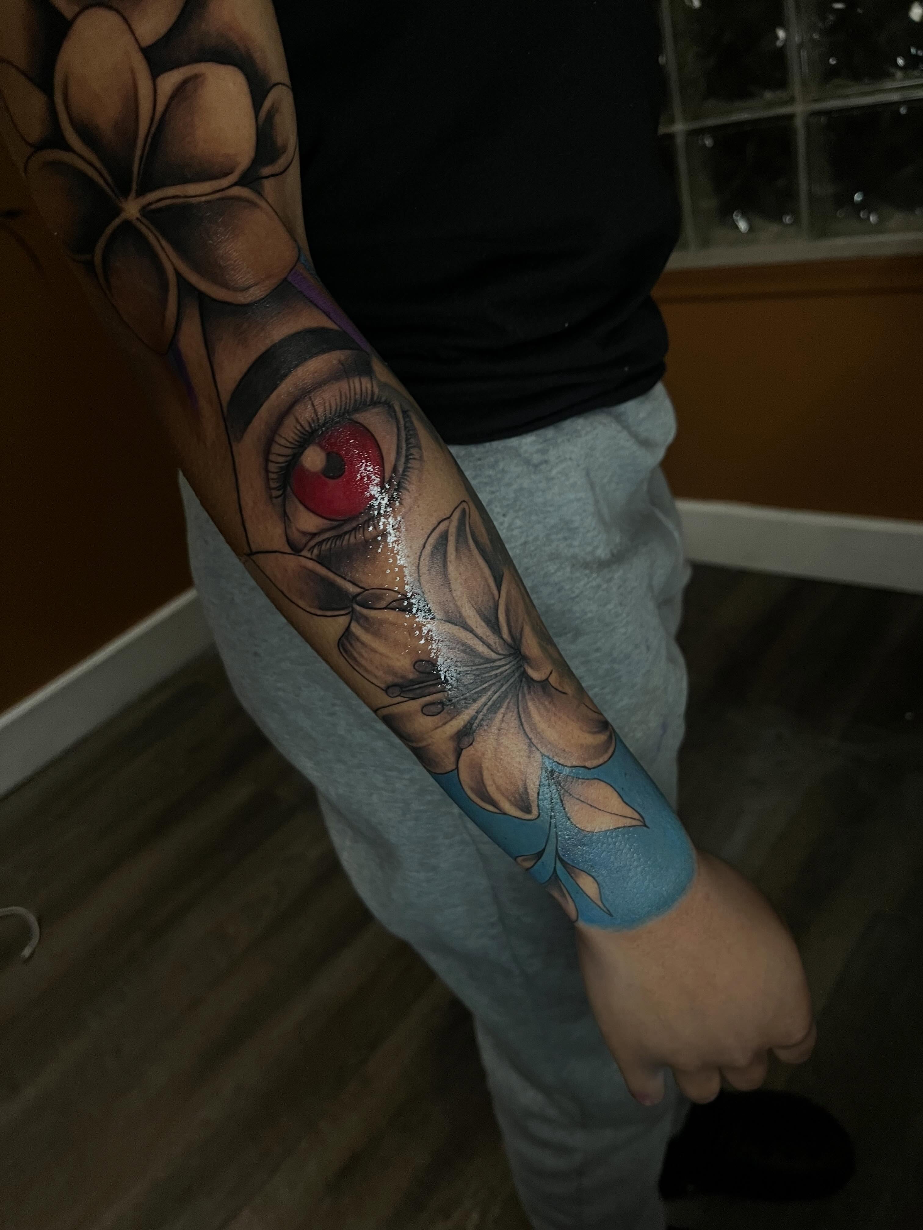 Eye with flower realism tattoo on the forearm by Tam💟👩🏽‍🎨