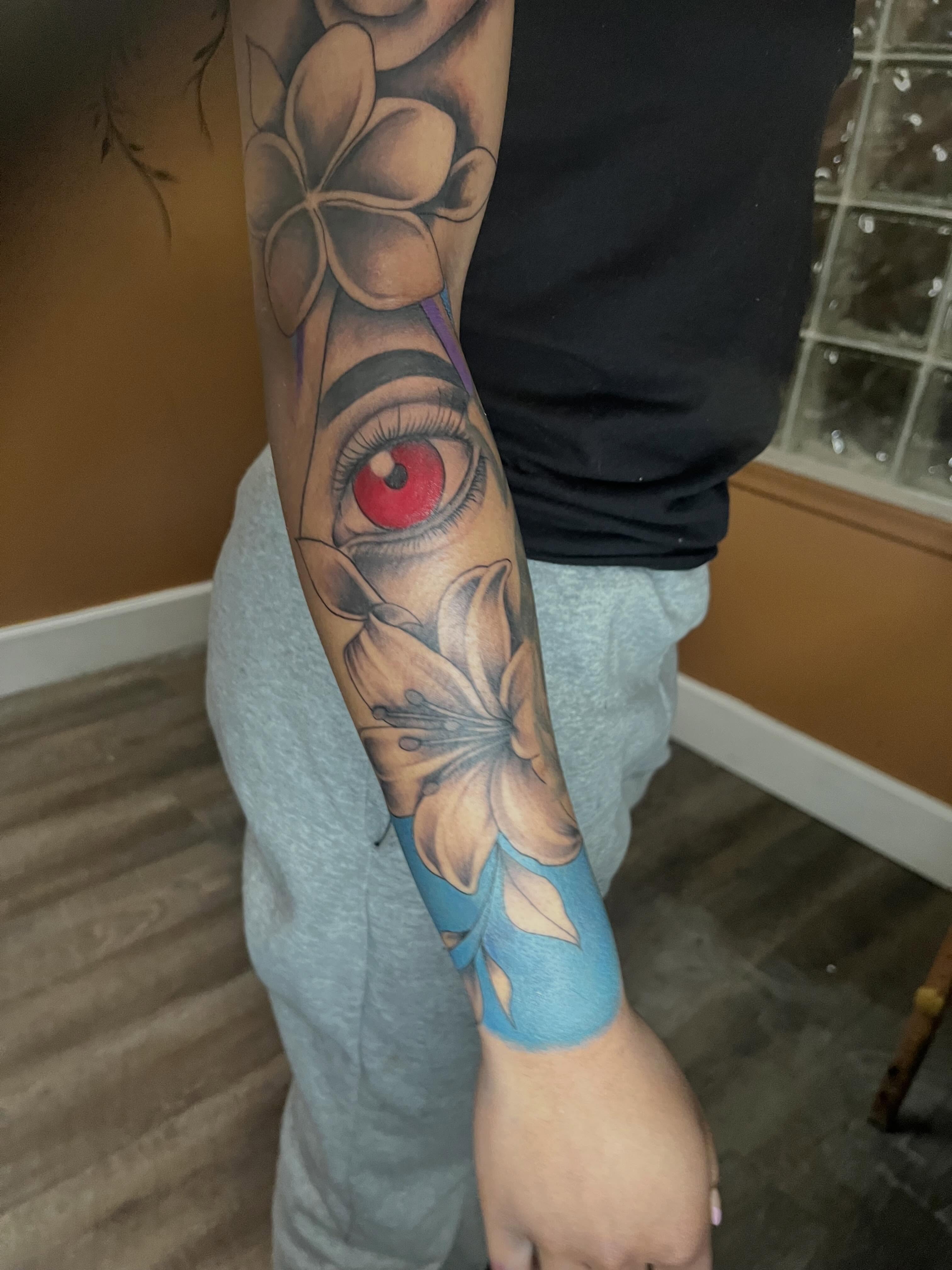Eye with flowers realism tattoo on the forearm by Tam💟👩🏽‍🎨