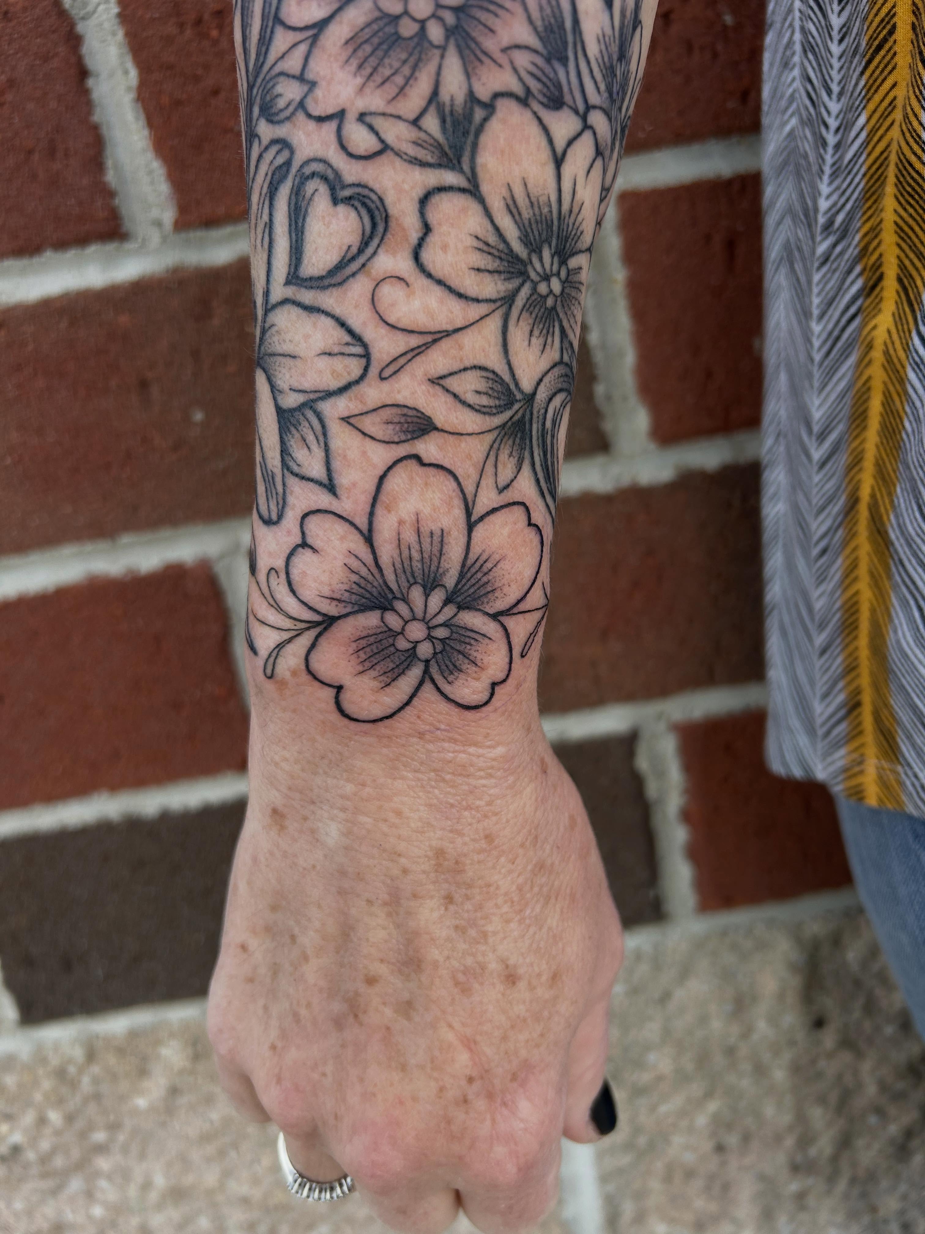 Floral design black and grey tattoo on the forearm by Cassidy Hammer, Westland, Michigan