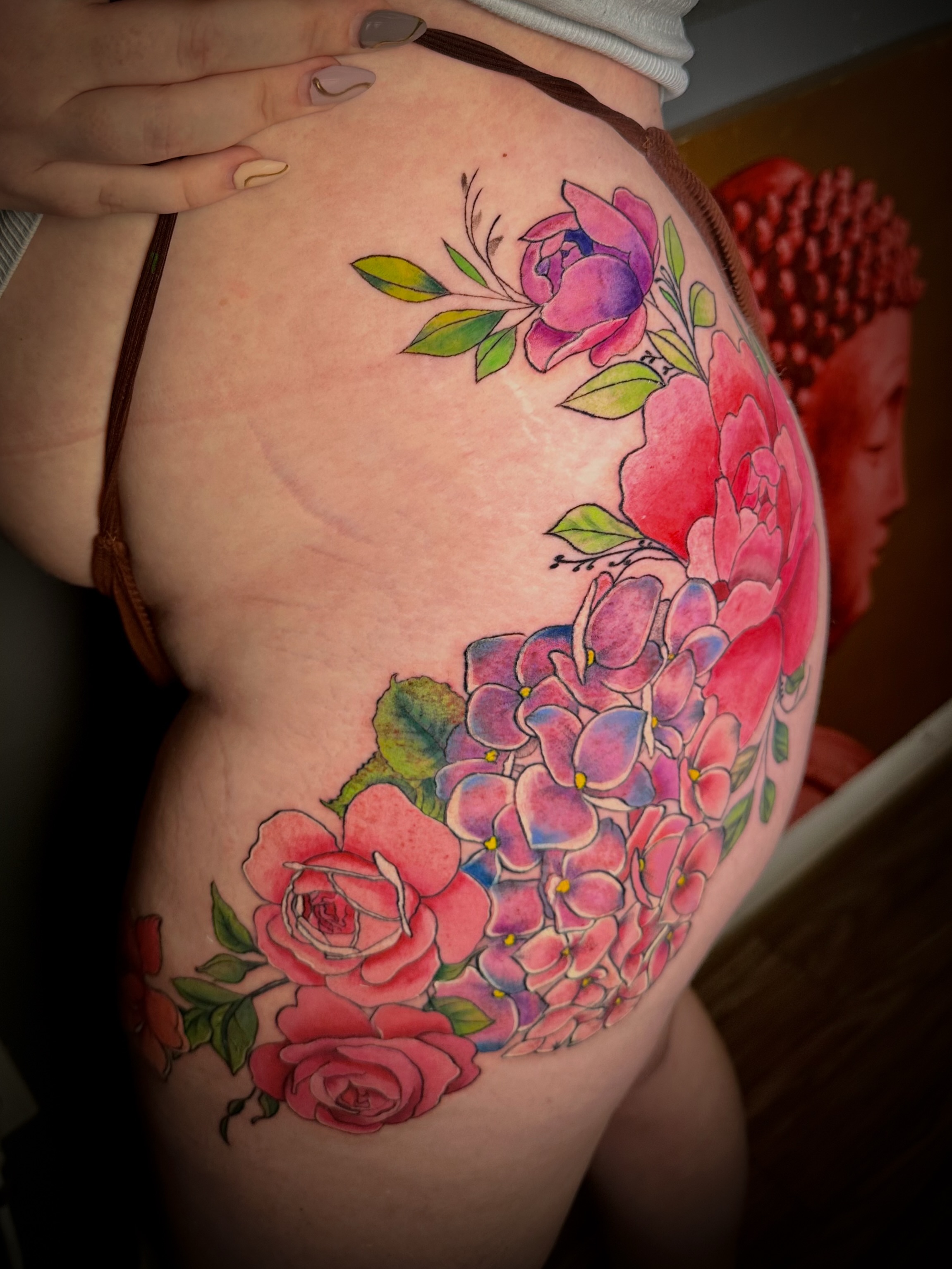Floral bouquet watercolor tattoo on the thigh by Jennifer Ramirez