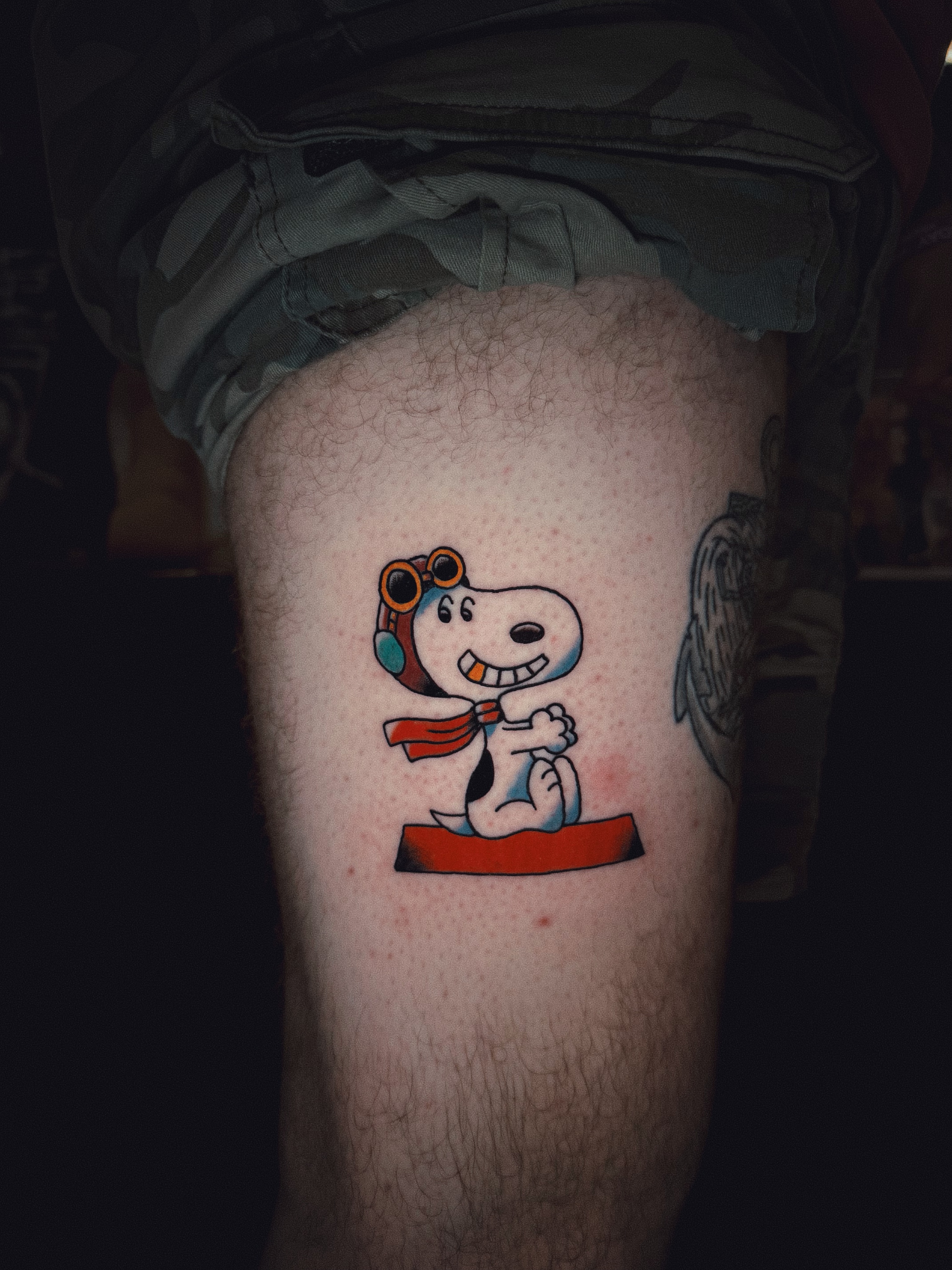 Snoopy illustrative tattoo on the thigh by Dustie Pitstick