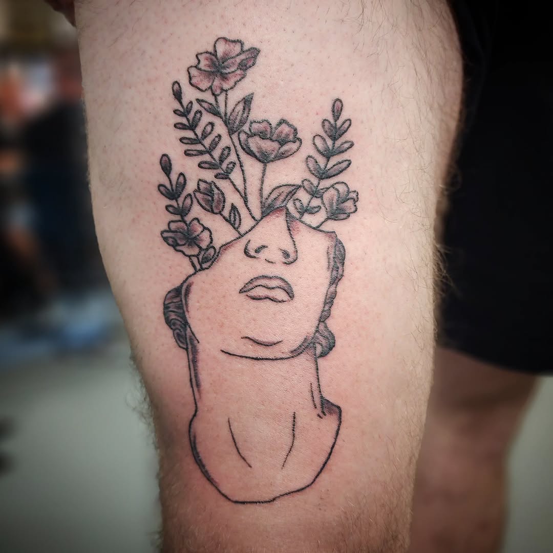 Statue head with flowers sketch tattoo on the thigh by Anntonietta Borzacchiello