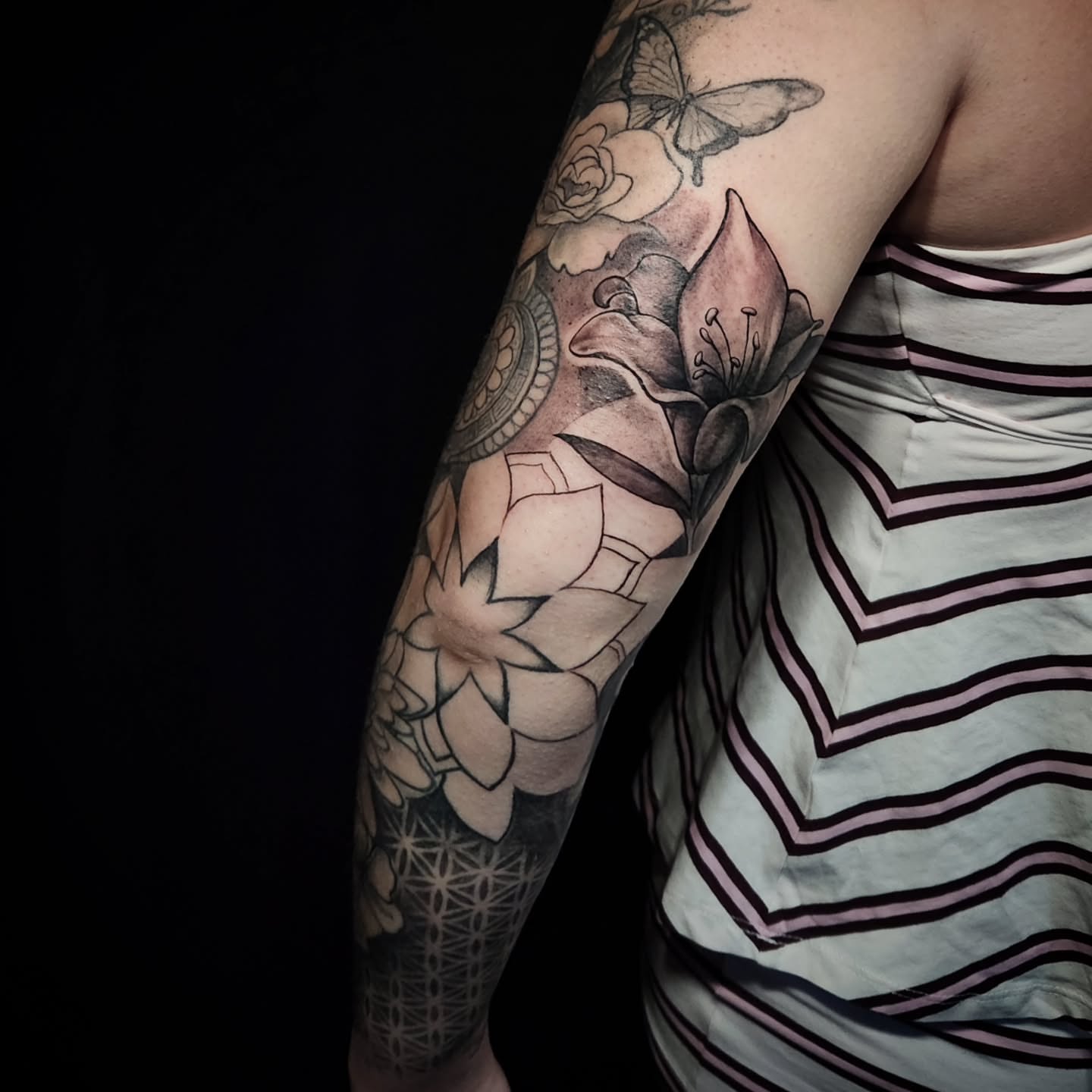 Lotus flowers and butterflies realism tattoo on the forearm by Arthur Whitney Shail