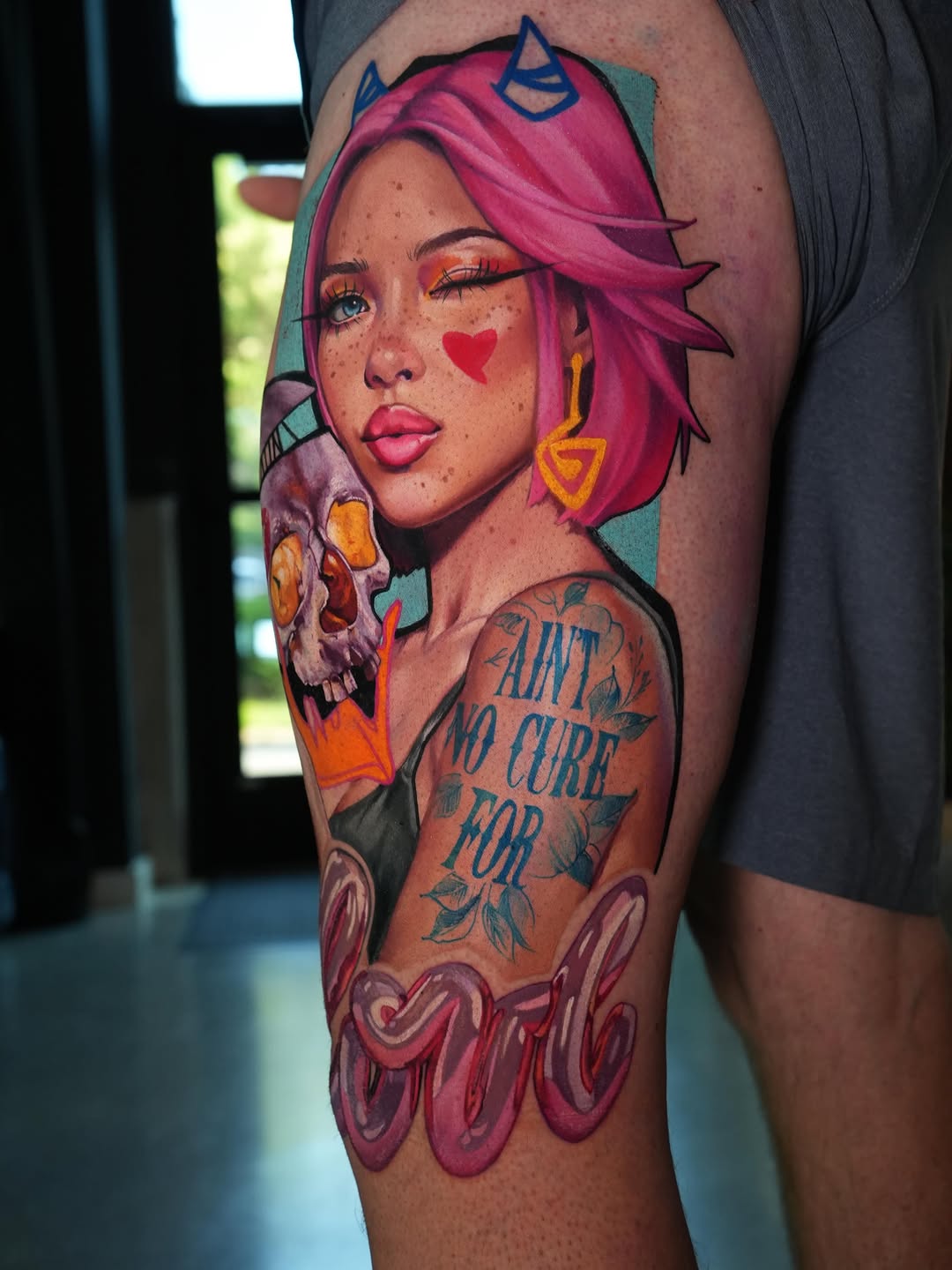 Woman holding skull with lettering neo-traditional tattoo on the upper arm by Daria Pirojenko